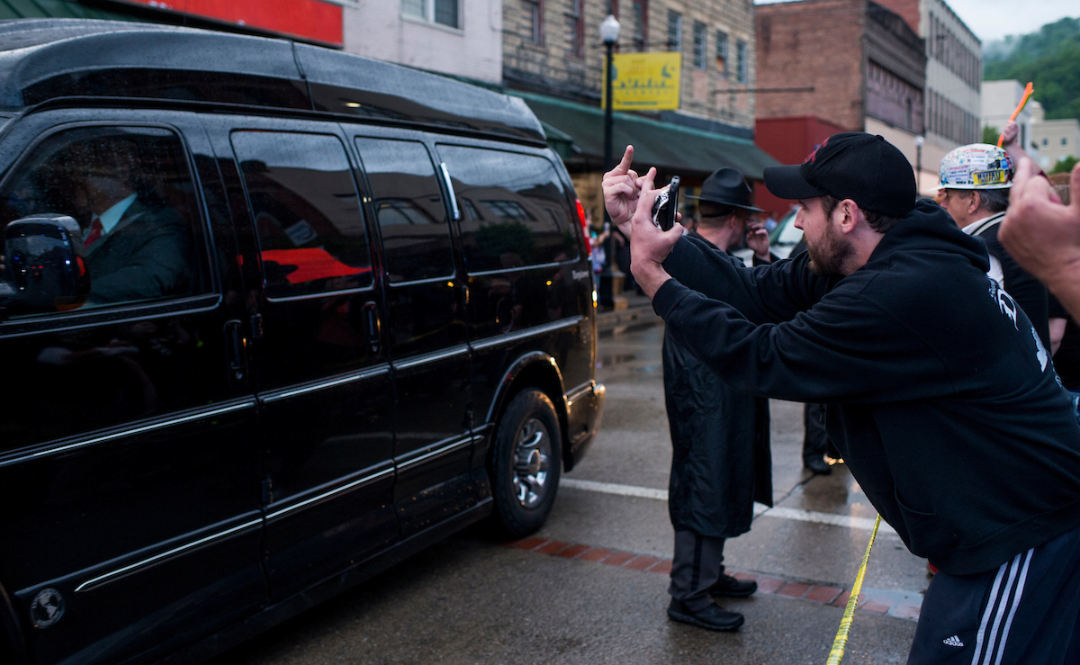UNITED STATES - MAY 2: Protesters gesture and yell as presidential candidate Hillary Clinton pulls away after touring a health and wellness center in Williamson, W. Va., on Monday, May 2, 2016. Several dozen protesters stood in the rain to voice their opposition to Hillary Clinton's visit to coal country. (Photo By Bill Clark/CQ Roll Call)