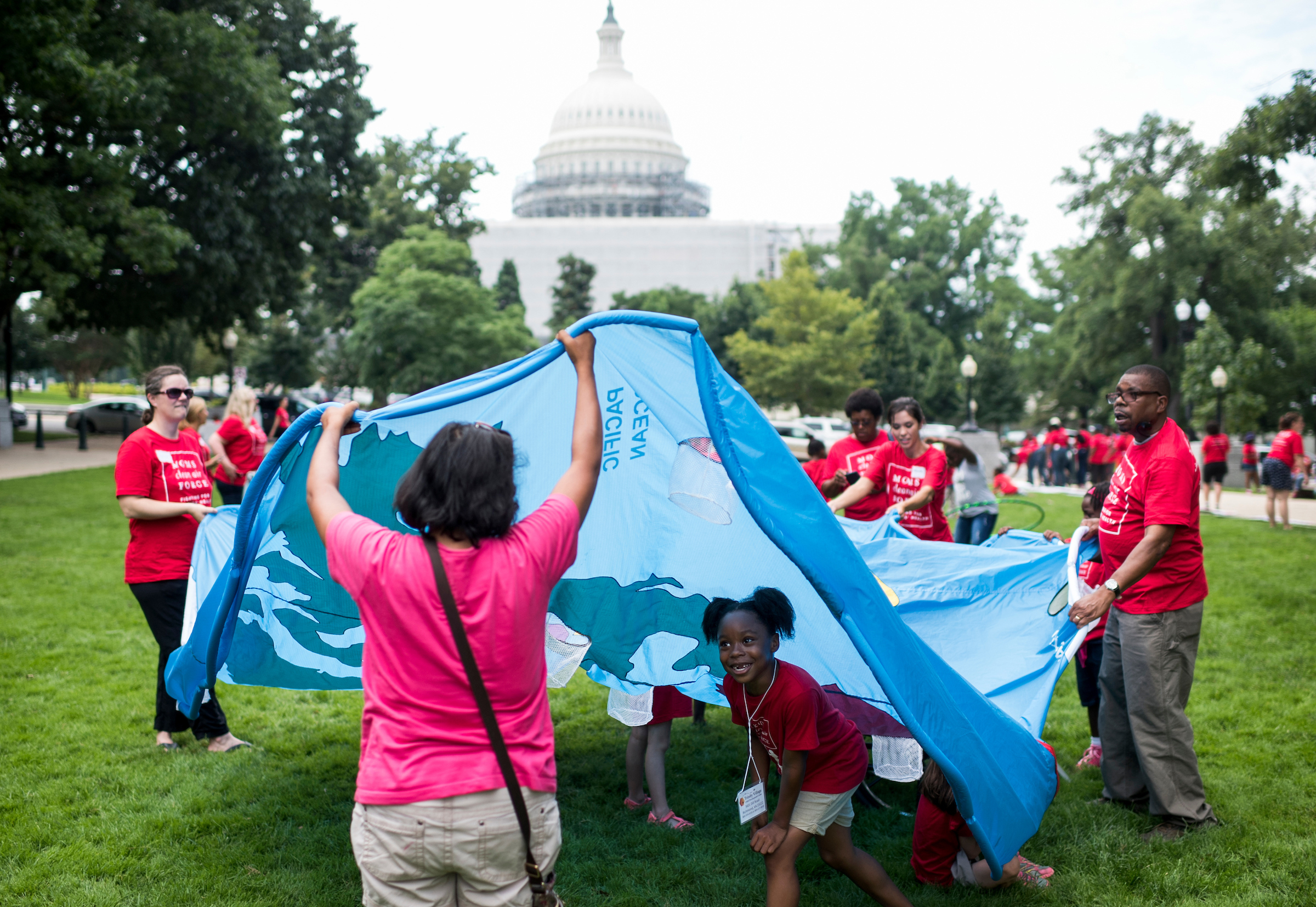 Kids play under a fabric map of the world during the Moms Clean Air Force "play-in for climate action" in Upper Senate Park in July. (Bill Clark/CQ Roll Call file photo)