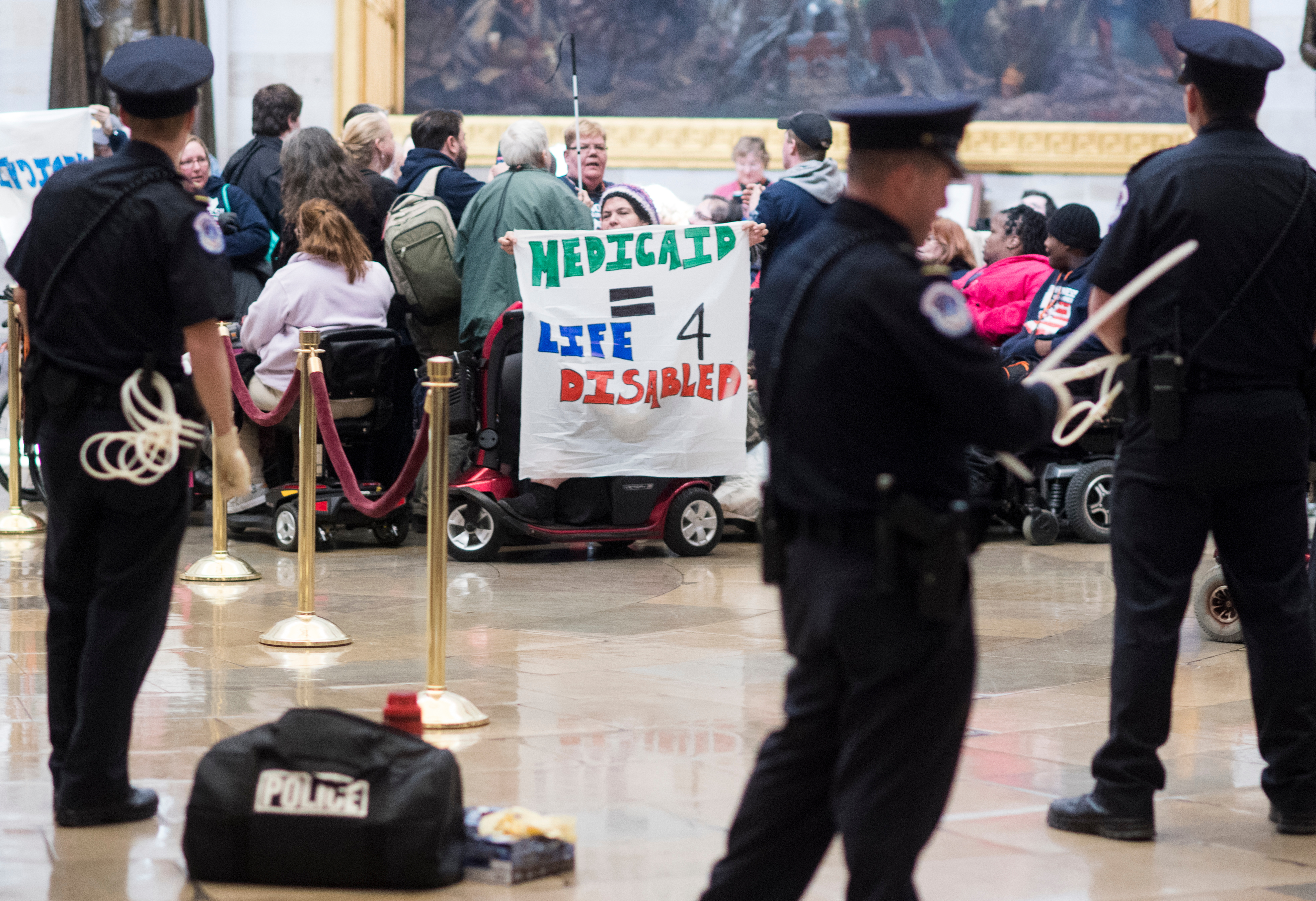 U.S. Capitol Police prepare flex cuffs to arrest members of ADAPT protesting in the Capitol rotunda on Tuesday against the American Health Care Act of 2017 and cuts to Medicaid. (Bill Clark/CQ Roll Call)