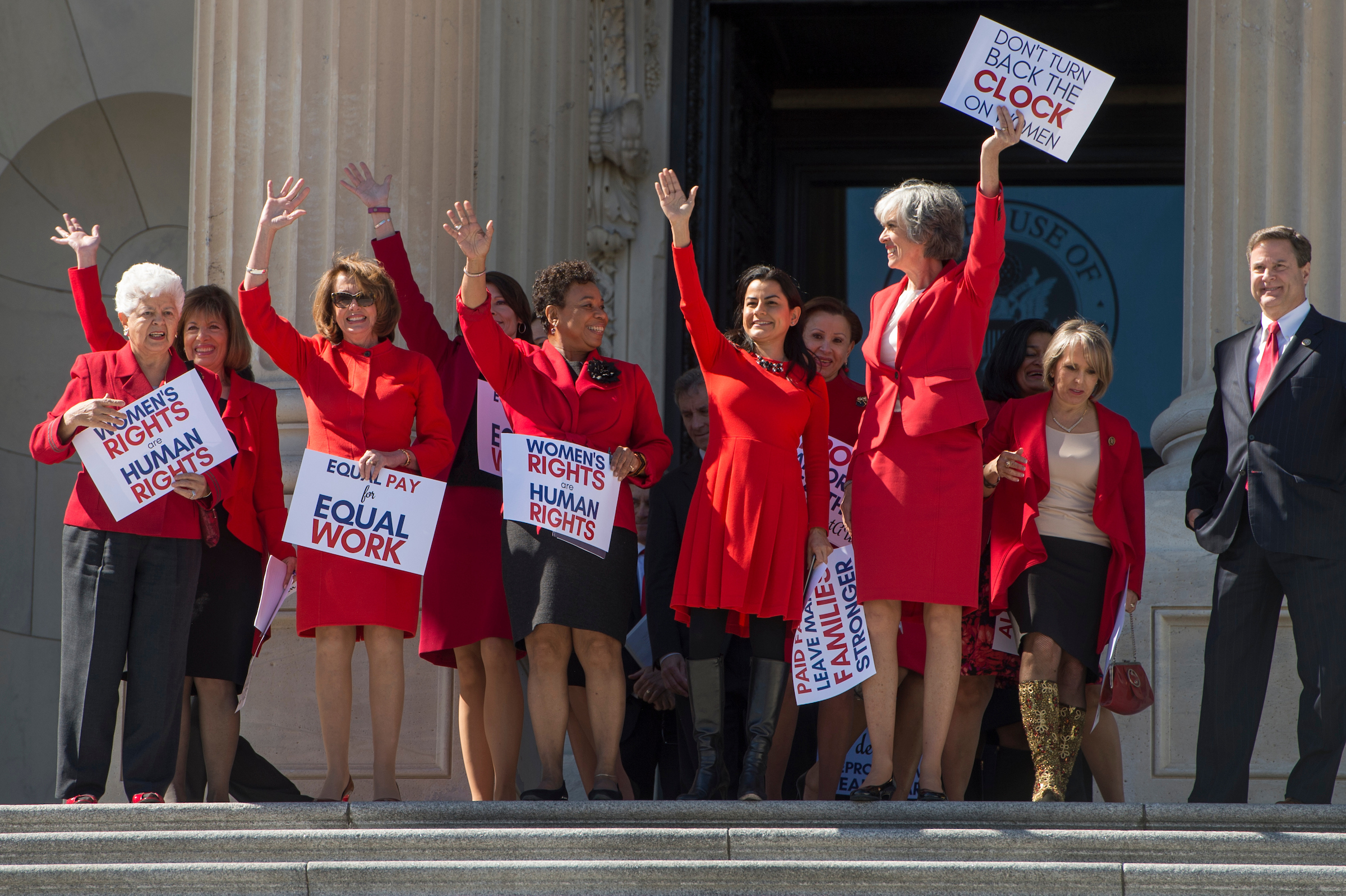 From left, Reps. Grace F. Napolitano, Jackie Speier, and Nancy Pelosi of California, Cheri Bustos of Illinois, Barbara Lee and Nanette Barragán of California, Nydia M. Velázquez of New York, Katherine M. Clark of Massachusetts, and Michelle Lujan Grisham of New Mexico wear red as they descend the House steps to support “A Day Without Women” on March 8. (Tom Williams/CQ Roll Call)