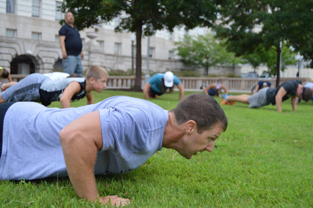 Markwayne Mullin (R-OK) does a push-up while leading the Congressional Men's Health Caucus Workout. (Ana Fadich, VP of Men's Health Network)