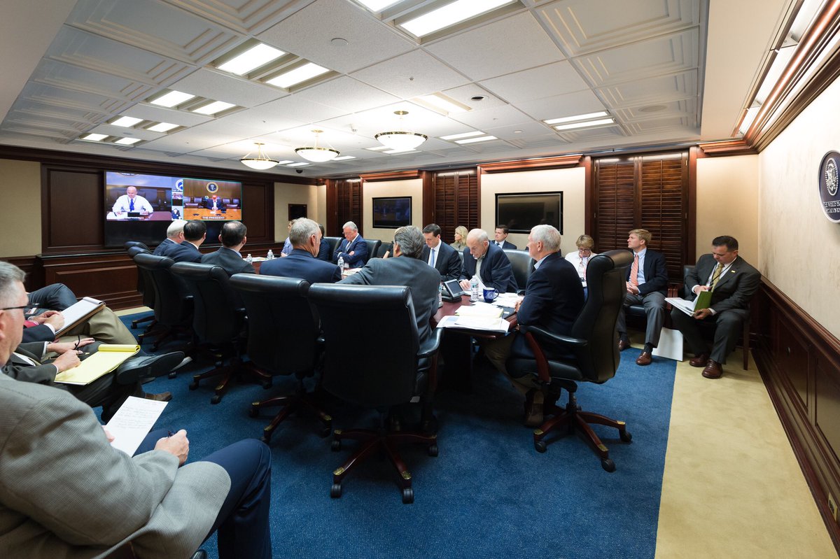 Vice President Mike Pence (far right, seated at table) sits at the head of the table on Sunday in the White House Situation Room as senior officials discussed Hurricane Harvey. President Donald Trump was at Camp David, and is pictured on the right video screen. (White House photo)