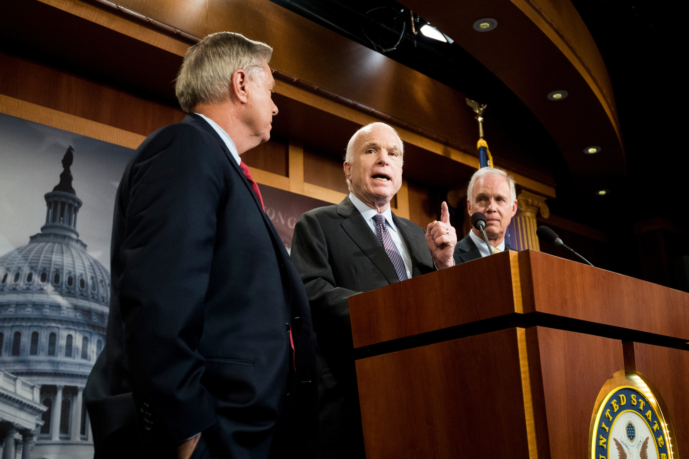 The office of Arizona Sen. John McCain, center, criticized Wisconsin Sen. Ron Johnson, right, for implying McCain’s brain cancer might have affected his health care vote. Also seen, South Carolina Sen. Lindsey Graham. (Bill Clark/CQ Roll Call)