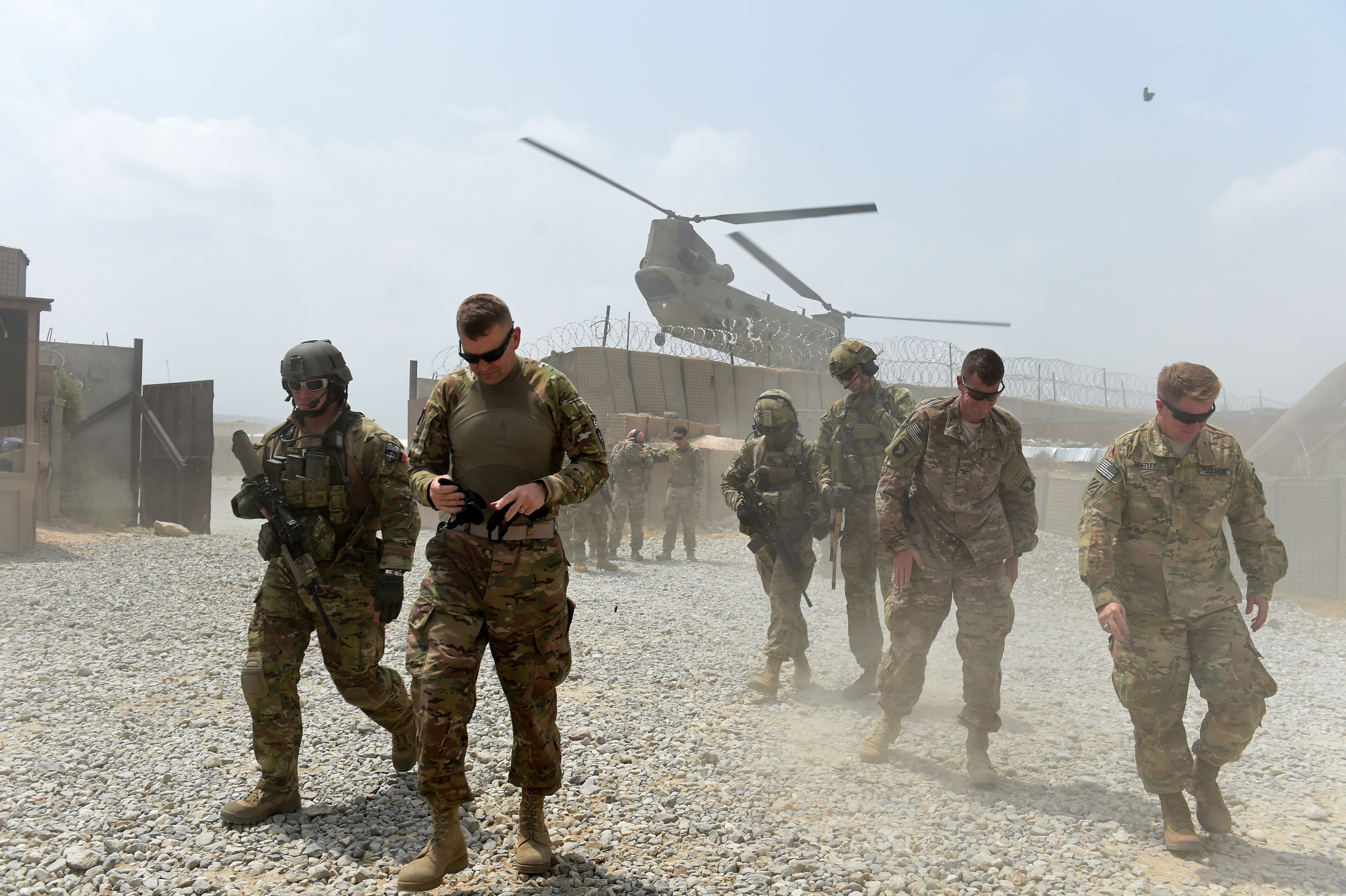 U.S. Army soldiers walk as a NATO helicopter flies overhead at Forward Operating Base Connelly in the Khogyani District in the eastern province of Nangarhar, Afghanistan. President Donald Trump and Afghan President Ashraf Ghani see the situation there differently, according to comments Thursday. (WAKIL KOHSAR/AFP/Getty Images)