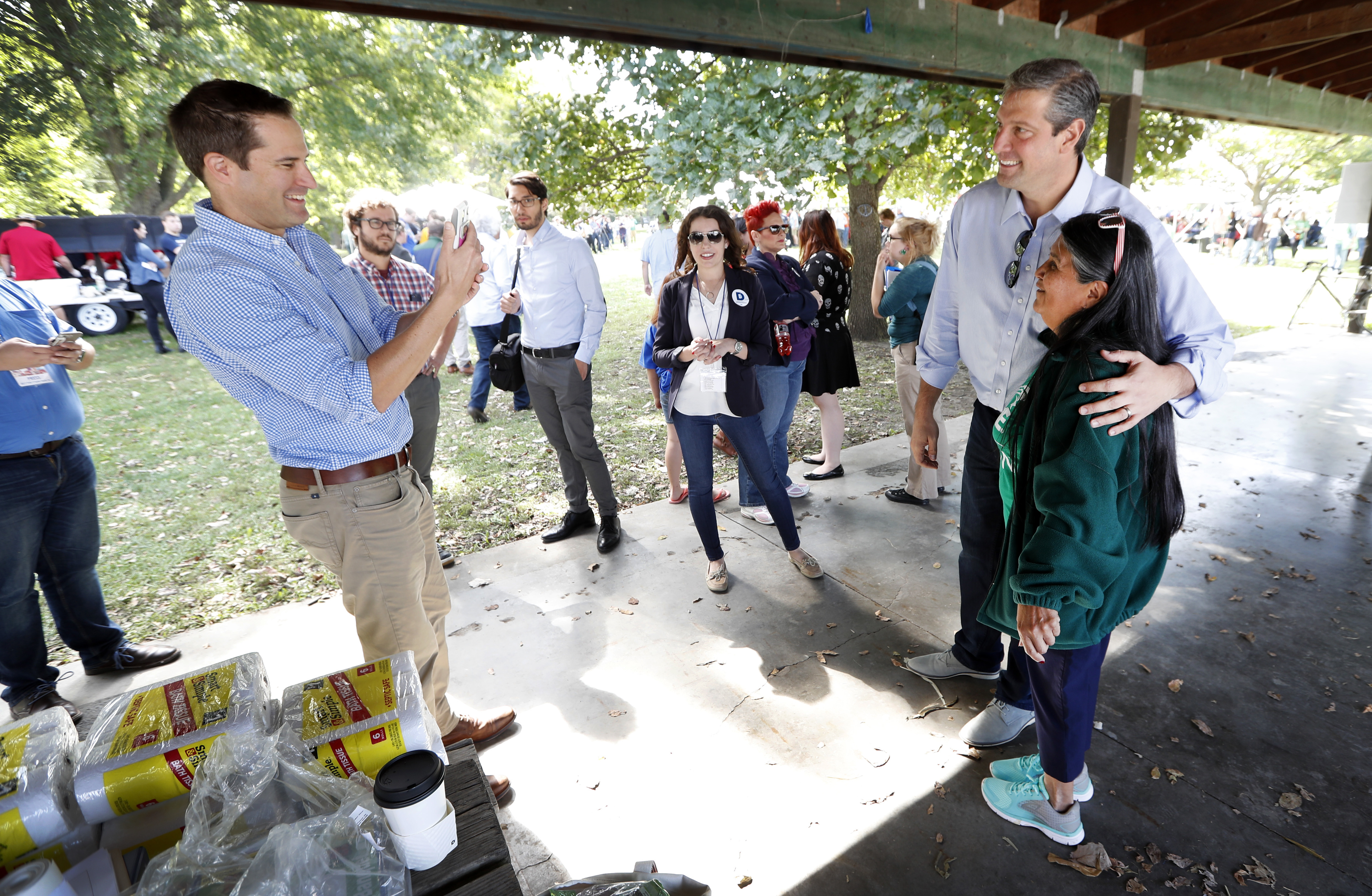 U.S. Rep. Seth Moulton, D-Mass., left, takes a photo of U.S. Rep. Tim Ryan, D-Ohio, with Paula Martinez, of Carlisle, Iowa, during the Polk County Democrats Steak Fry, Saturday, Sept. 30, 2017, in Des Moines, Iowa. (AP Photo/Charlie Neibergall)