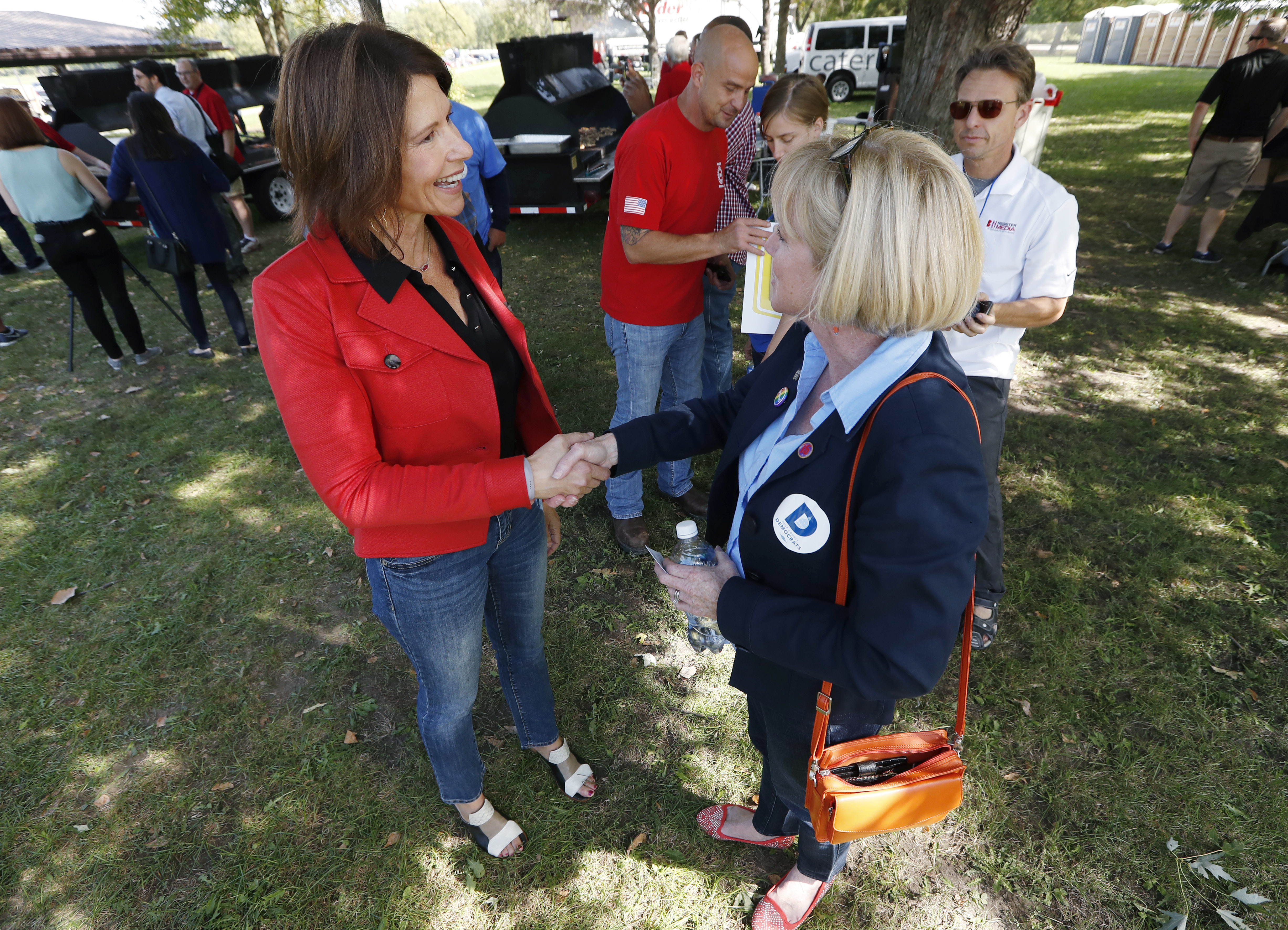 U.S. Rep. Cheri Bustos, D-Ill., left, talks with Iowa gubernatorial candidate Cathy Glasson during the Polk County Democrats Steak Fry, Saturday, Sept. 30, 2017, in Des Moines, Iowa. (AP Photo/Charlie Neibergall)