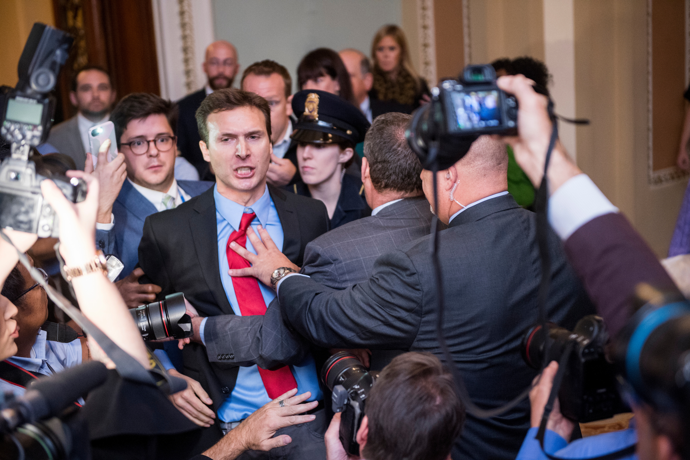 Secret Service and Capitol Police grab a protester after he threw Russian flags at Senate Majority Leader Mitch McConnell, R-Ky., and President Donald Trump as they arrived for the Senate Republicans’ policy lunch in the Capitol on Tuesday, Oct. 24, 2017. (Bill Clark/CQ Roll Call)