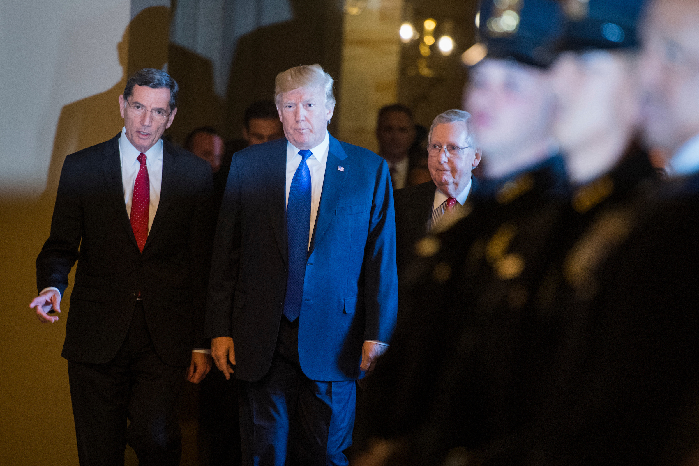 President Donald Trump arrives with Sen. John Barrasso, R-Wyo., left, and Senate Majority Leader Mitch McConnell, R-Ky., for the Republicans’ policy luncheon on Tuesday. (Photo By Tom Williams/CQ Roll Call)