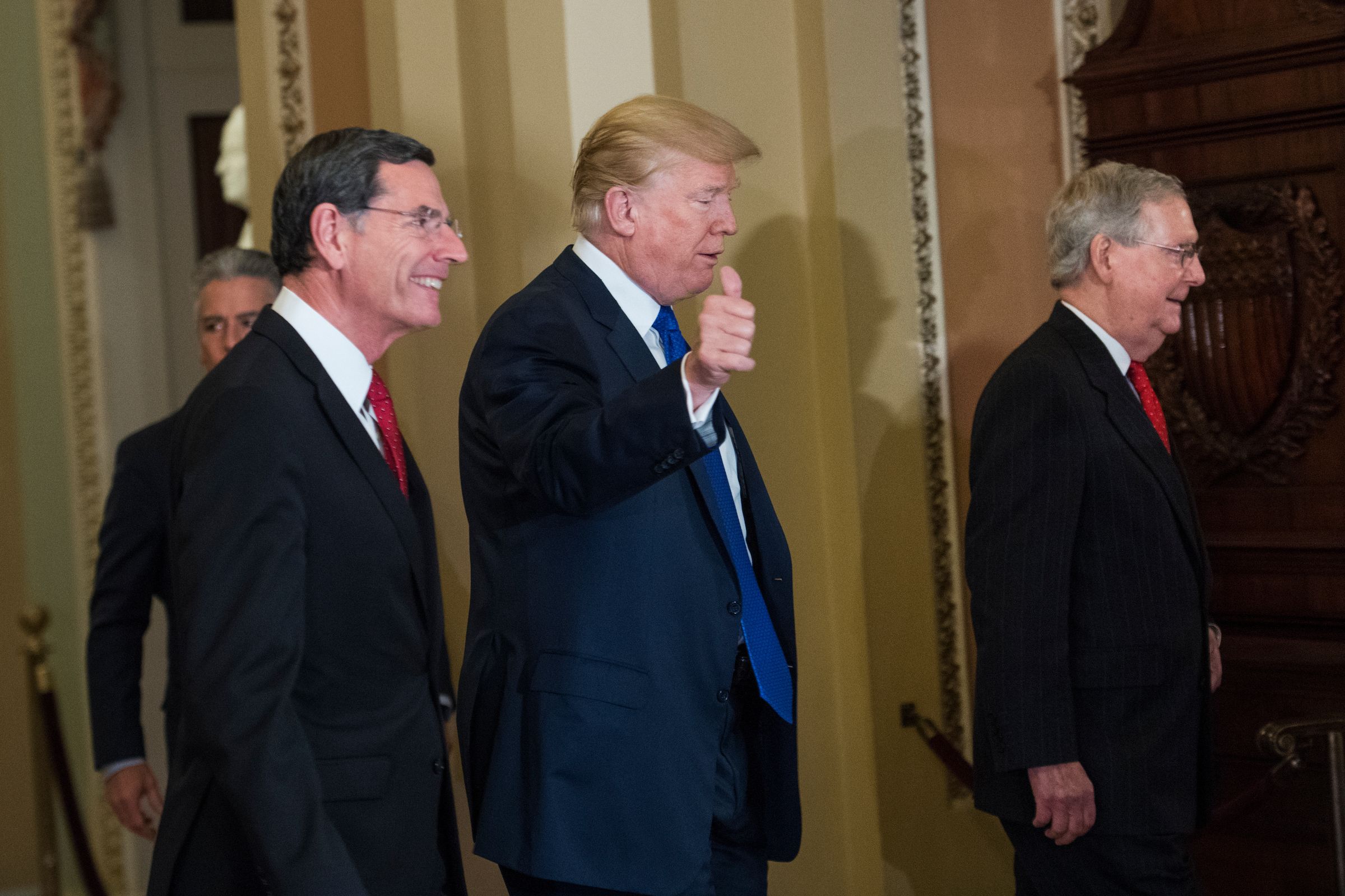 President Donald Trump arrives with Sen. John Barrasso, R-Wyo., left, and Senate Majority Leader Mitch McConnell, R-Ky., for Tuesday’s Republican Senate policy lunch in the Capitol. (Tom Williams/CQ Roll Call)