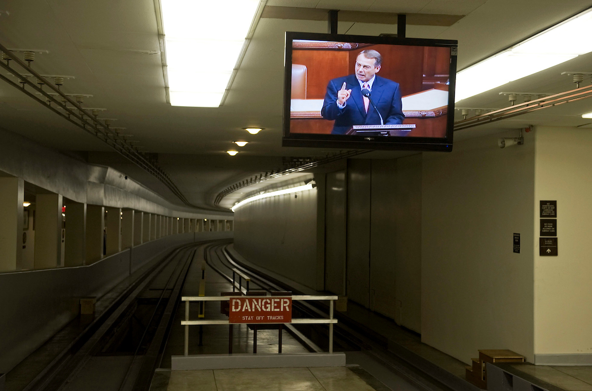 Speaker John Boehner, R-Ohio, is seen on a closed circuit television in the subway leading to the Rayburn Building in 2011, soon before the House voted on the Budget Control Act. (Tom Williams/Roll Call file photo)