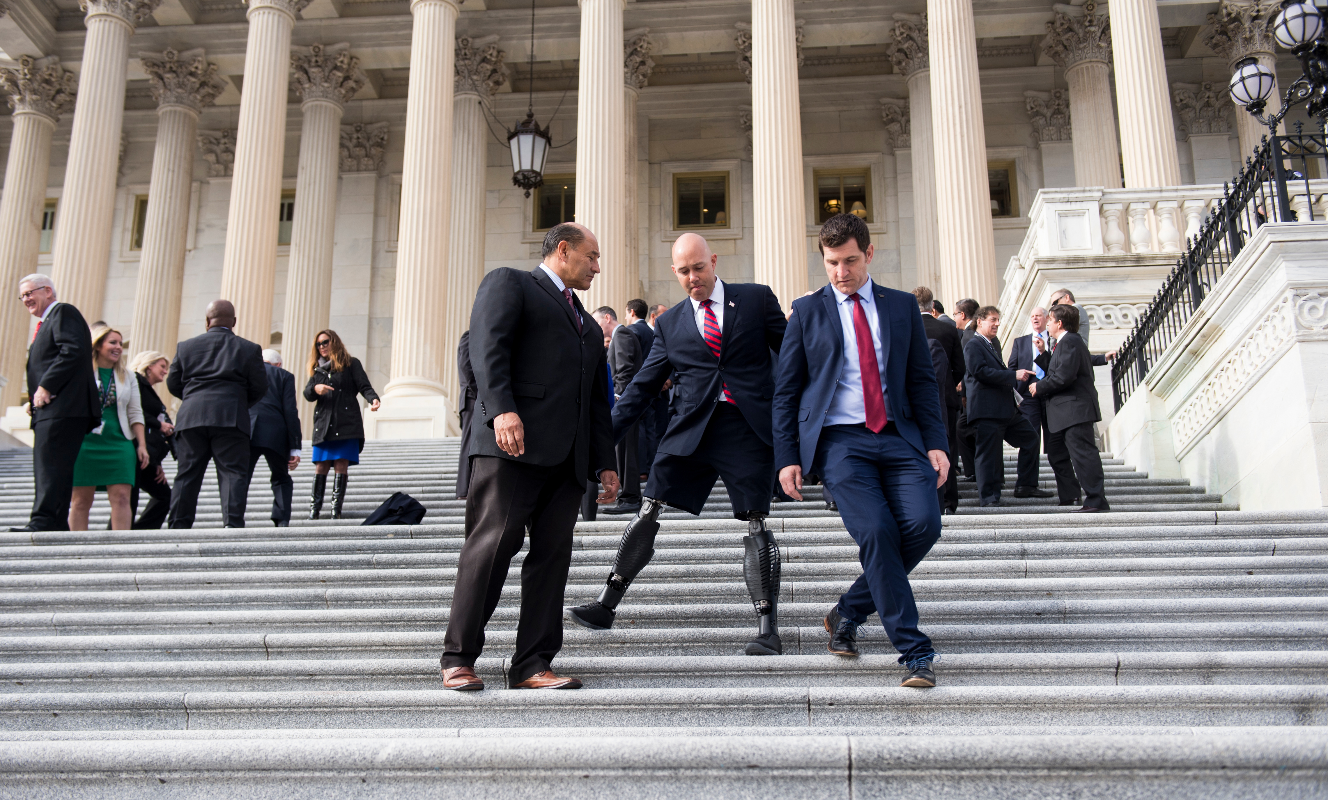 From left, Reps. Lou Correa of California, Brian Mast of Florida and Scott Taylor of Virginia walk down the House steps after the group photo for the freshman class during orientation week in November 2016. (Bill Clark/CQ Roll Call file photo)