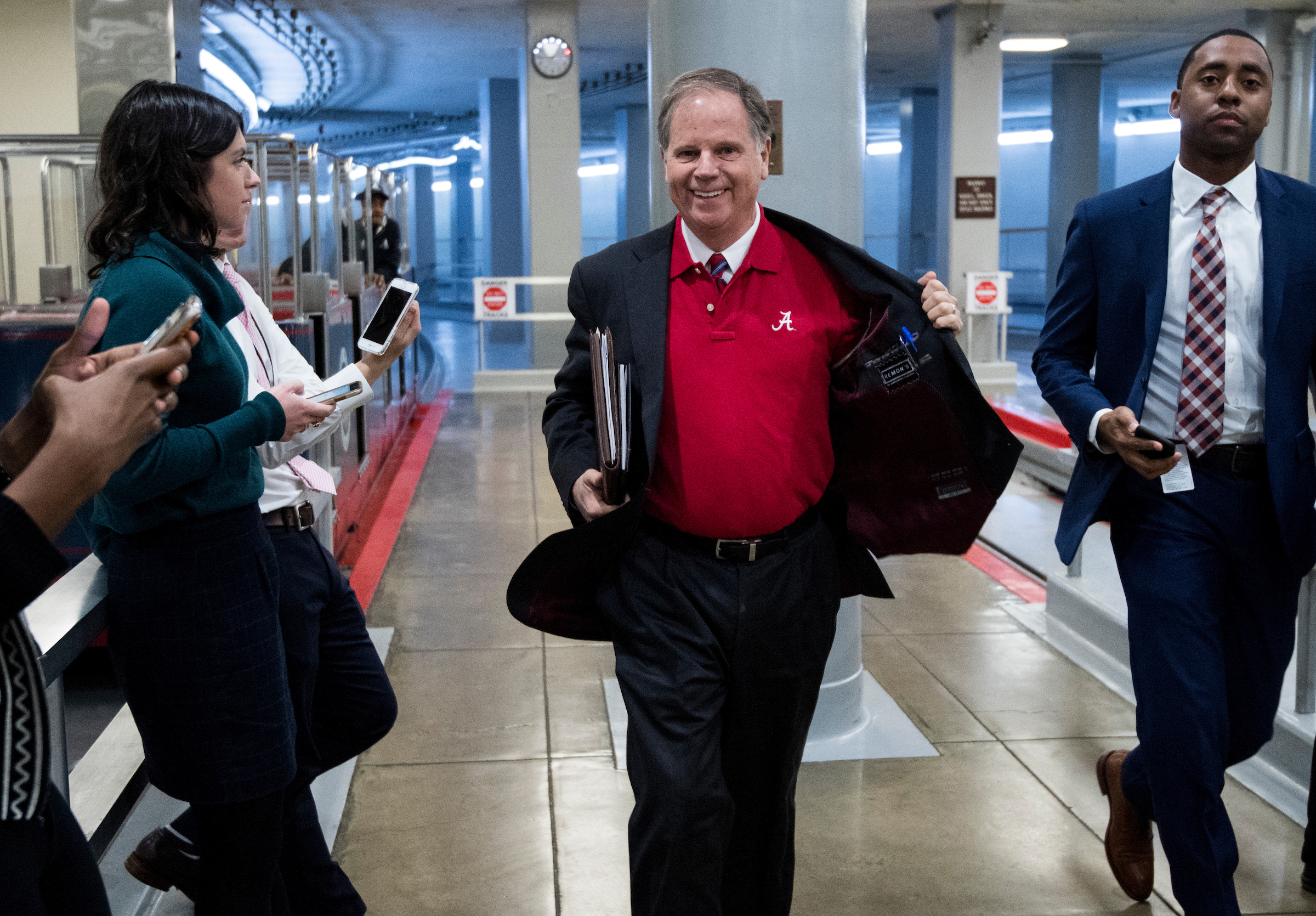 UNITED STATES - JANUARY 9: Sen. Doug Jones, D-Ala., flashes his University of Alabama shirt as he arrives in the Capitol on Tuesday, Jan. 9, 2018. Alabama defeated the University of Georgia for the NCAA football championship. (Photo By Bill Clark/CQ Roll Call)