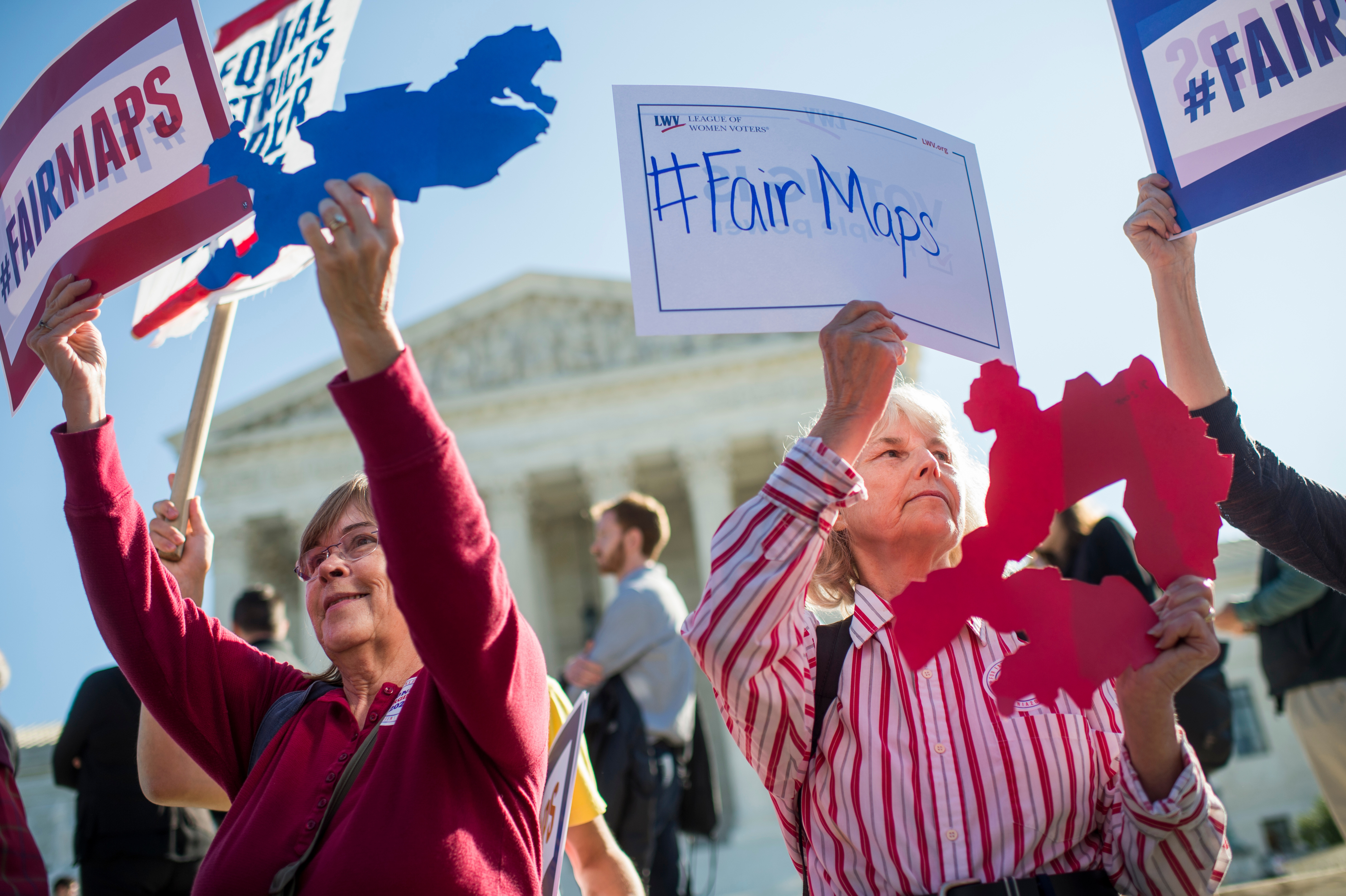 Shirley Connuck of Falls Church, Virginia, right, holds up a sign representing a district in Texas as protesters demonstrate outside the Supreme Court on Oct. 3, 2017, as the court was hearing a case on partisan gerrymandering. (Tom Williams/CQ Roll Call)