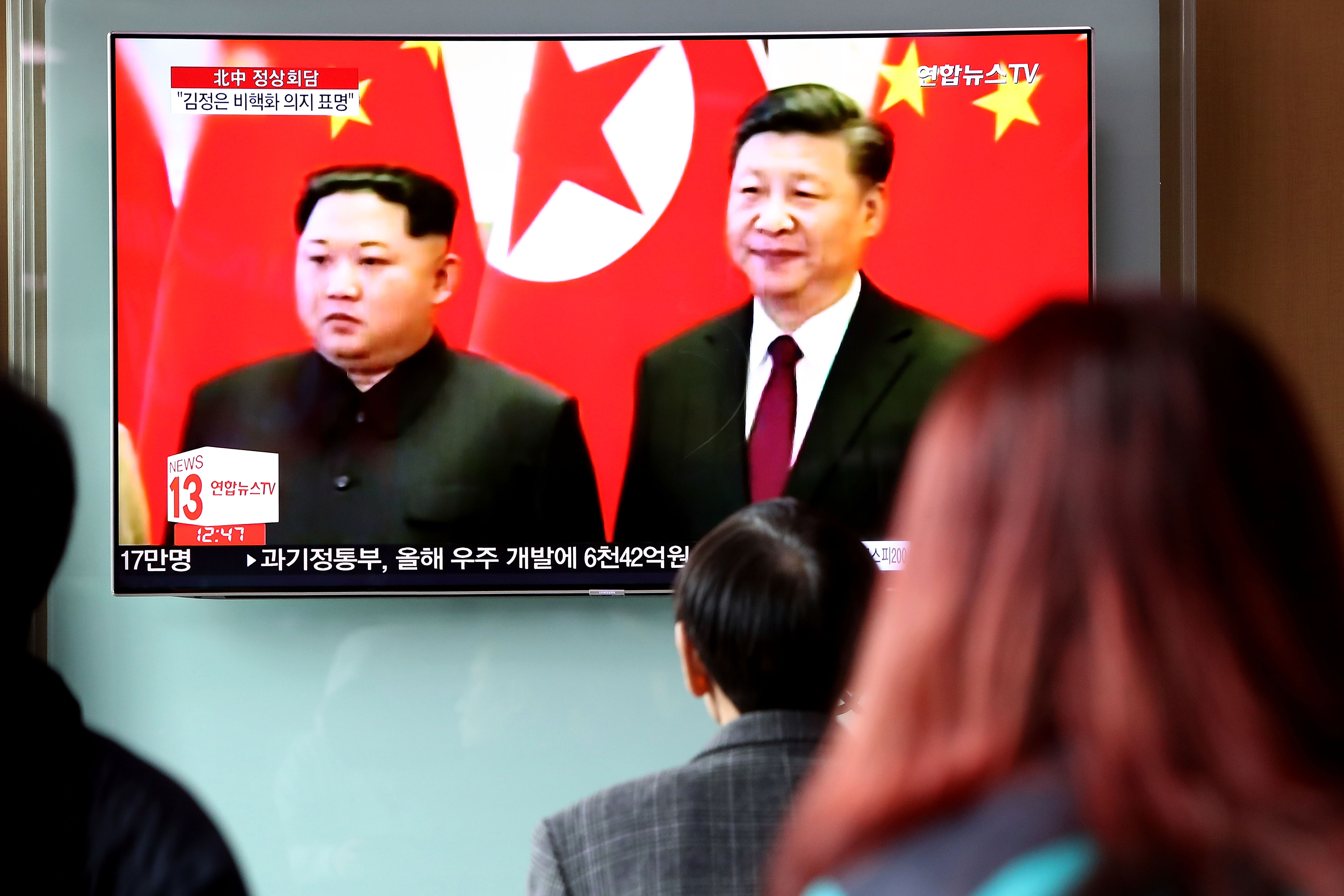 South Koreans watch a television broadcast reporting North Korean leader Kim Jong-un’s meeting Chinese President Xi Jinping at Seoul Railway Station in March. (Chung Sung-Jun/Getty Images file photo)