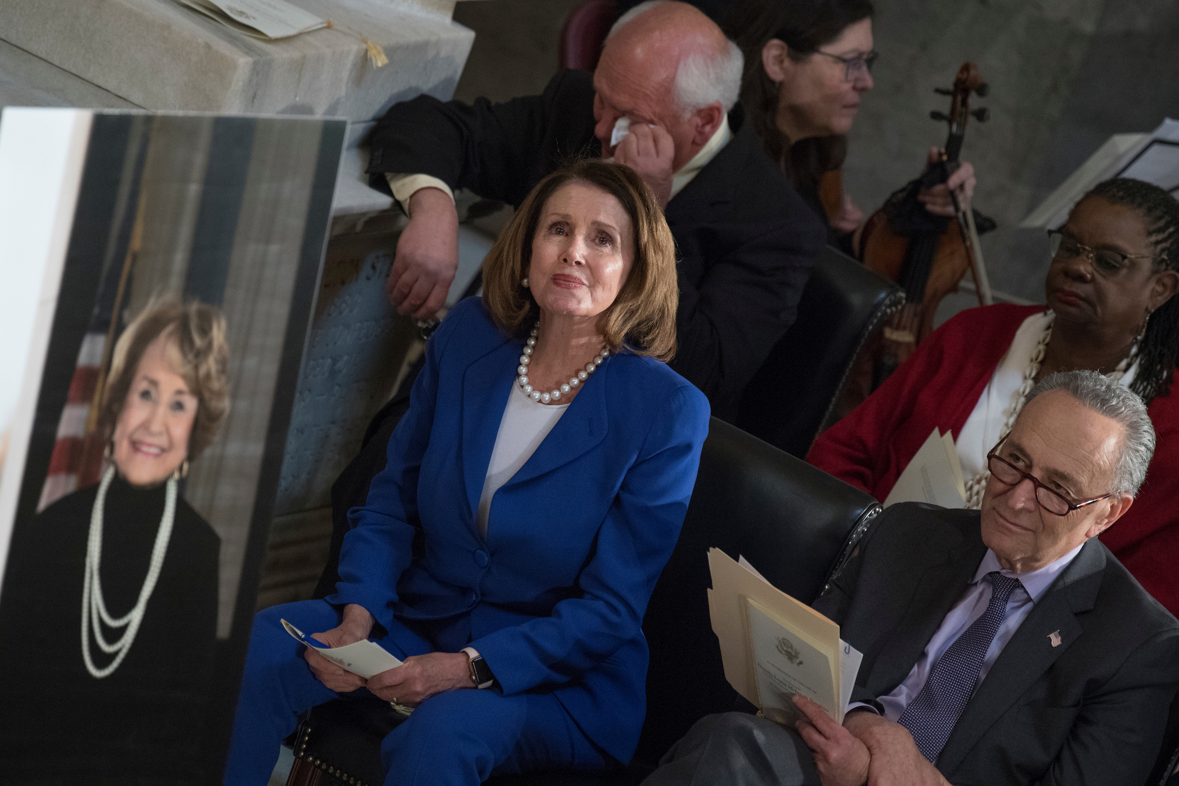 House Minority Leader Nancy Pelosi, D-Calif., center, Senate Minority Leader Charles Schumer, D-N.Y., right, Reps. Gwen Moore, D-Wis., and Paul Tonko, D-N.Y., listen to rendition of "Amazing Grace" during a memorial service for the late Rep. Louise Slaughter, D-N.Y., in the Capitol's Statuary Hall on April 18, 2018. Slaughter, pictured at left, passed away on March 16, 2018, at age 88. (Photo By Tom Williams/CQ Roll Call)