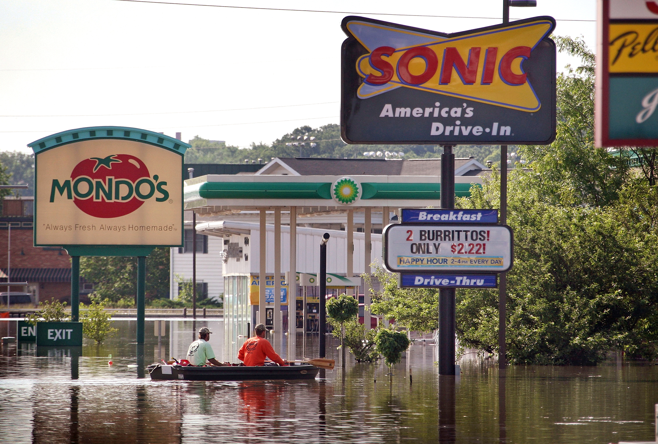 CORALVILLE, IA - JUNE 15: Two men row a boat to thru a flooded area of town known as the strip June 15, 2008 in Coralville, Iowa. The Iowa River is expected to crest in Coralville and Iowa City at record levels Tuesday. (Photo by Scott Olson/Getty Images)