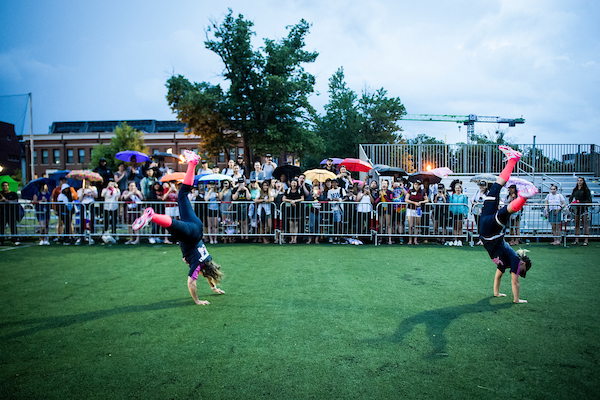 UNITED STATES - June 20: Reps. Michelle Lujan Grisham, D-N.M., left, and Kyrsten Sinema, D-Ariz., do cartwheels for a group of interns after the Congressional Women’s Softball Game at the Watkins Recreation Center in Capitol Hill Wednesday June 20, 2018. (Photo By Sarah Silbiger/CQ Roll Call)