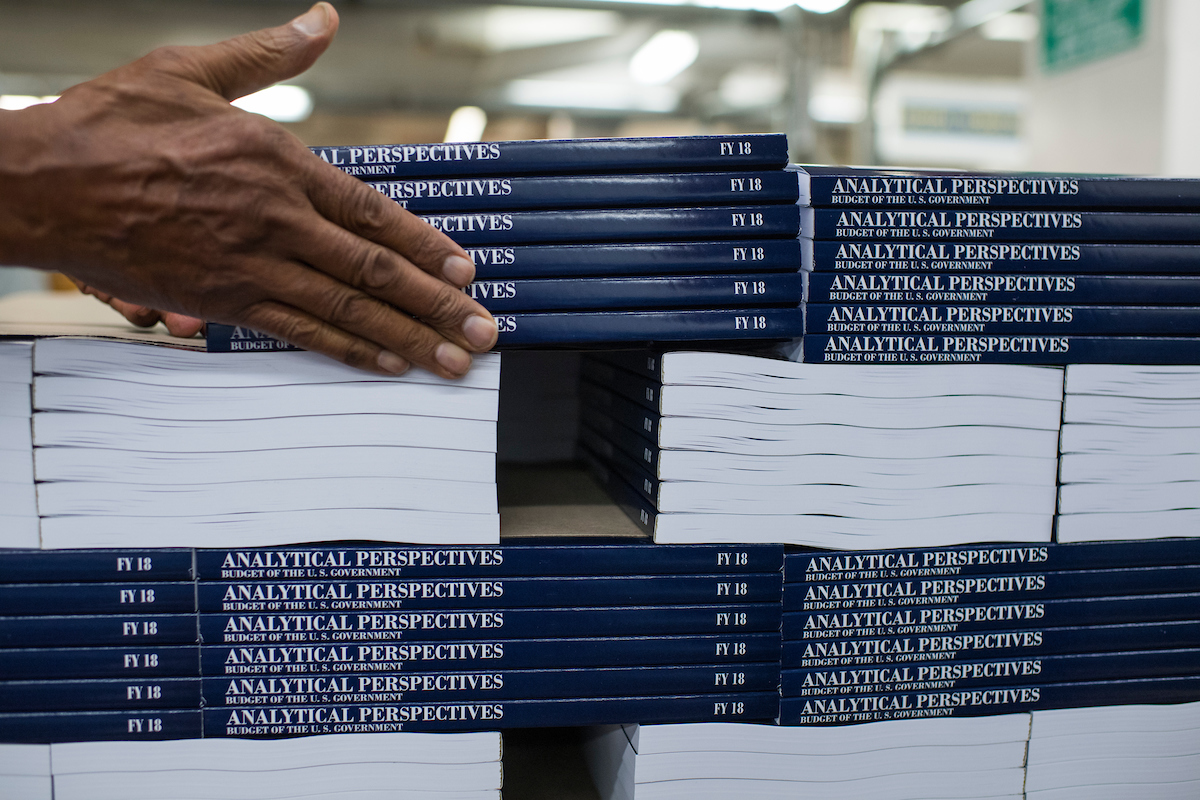 A worker stacks the budget for Fiscal Year 2018 at the Government Publishing Office's plant on North Capitol Street before a visit from OMB Director Mick Mulvaney and GPO Director Davita Vance-Cooks on May 19, 2017. (Tom Williams/CQ Roll Call file photo)