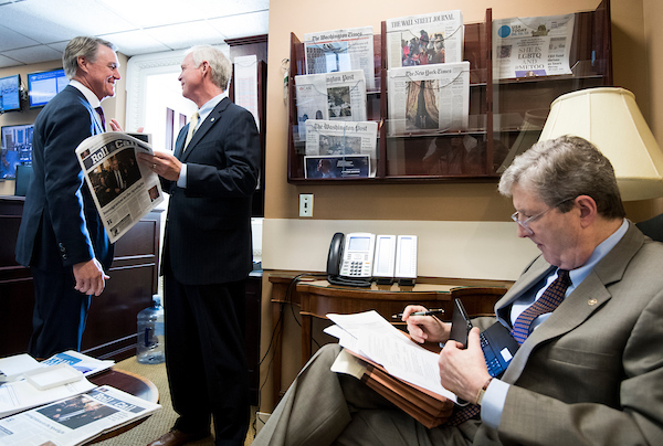 UNITED STATES - JUNE 19: From left, Sen. David Perdue, R-Ga., Sen. Ron Johnson, R-Wisc., and Sen. John Kennedy, R-La., wait in the U.S. Senate Radio & Television Correspondents Gallery for other senators to arrive for their ews conference in the Capitol on Tuesday, June 19, 2018, to call on the Senate to vote on the rescissions package. (Photo By Bill Clark/CQ Roll Call)