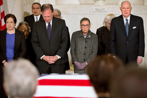 Supreme Court Justices, from left, Elena Kagan, Samuel Anthony Alito, Jr., Ruth Bader Ginsburg, and Anthony Kennedy participate in prayers at a private ceremony in the Great Hall of the Supreme Court in Washington, Friday, Feb. 19, 2016, where late Supreme Court Justice Antonin Scalia lies in repose. (AP Photo/Jacquelyn Martin, Pool)