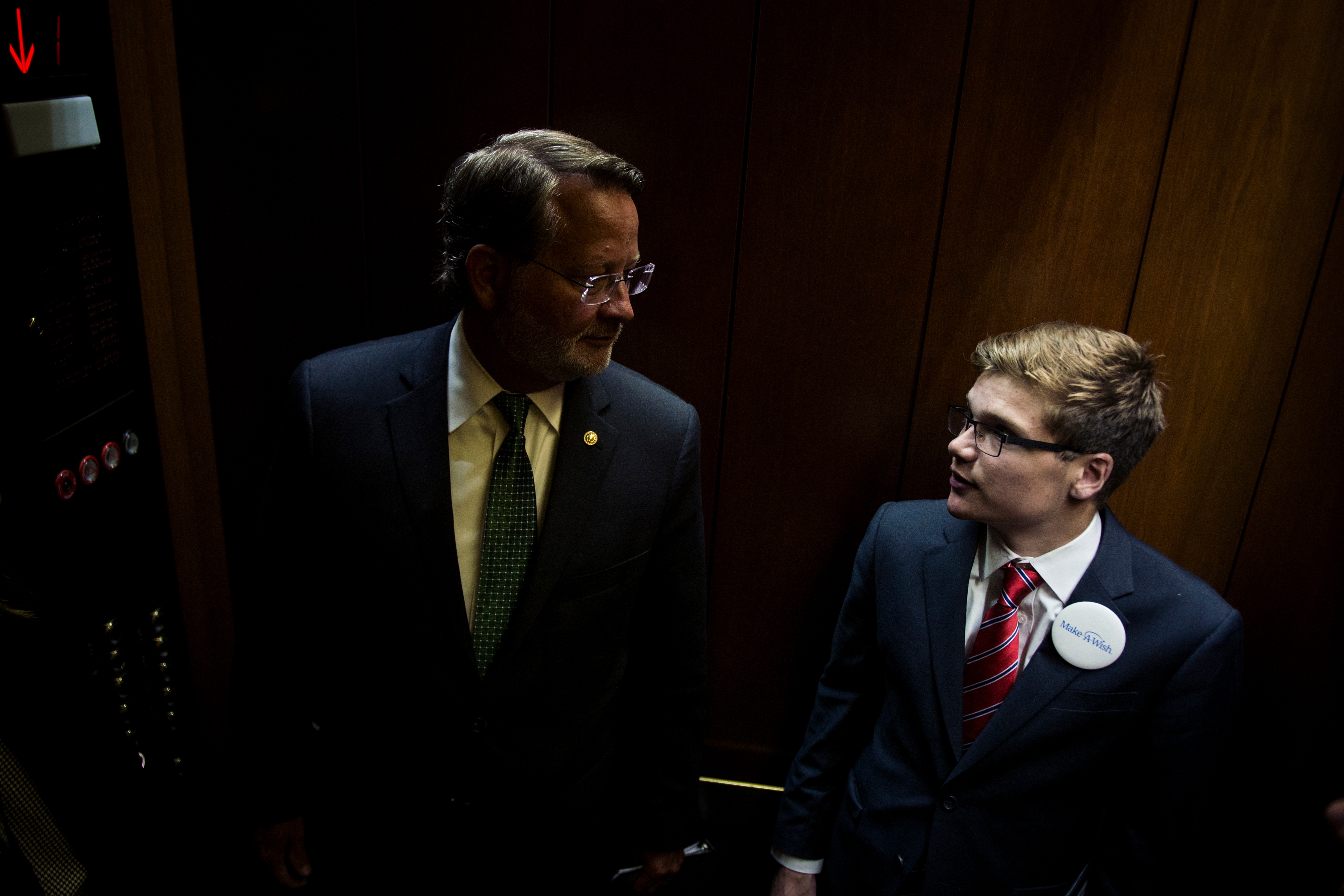 UNITED STATES: July 10: Make-A-Wish recipient and 'U.S. Senator For a Day' Thomas Stephenson and Sen. Gary Peters', D-Mich., ride the elevator to the Senate Subway in the Hart Senate Office Building Tuesday July 10, 2018. (Photo by Sarah Silbiger/CQ Roll Call)