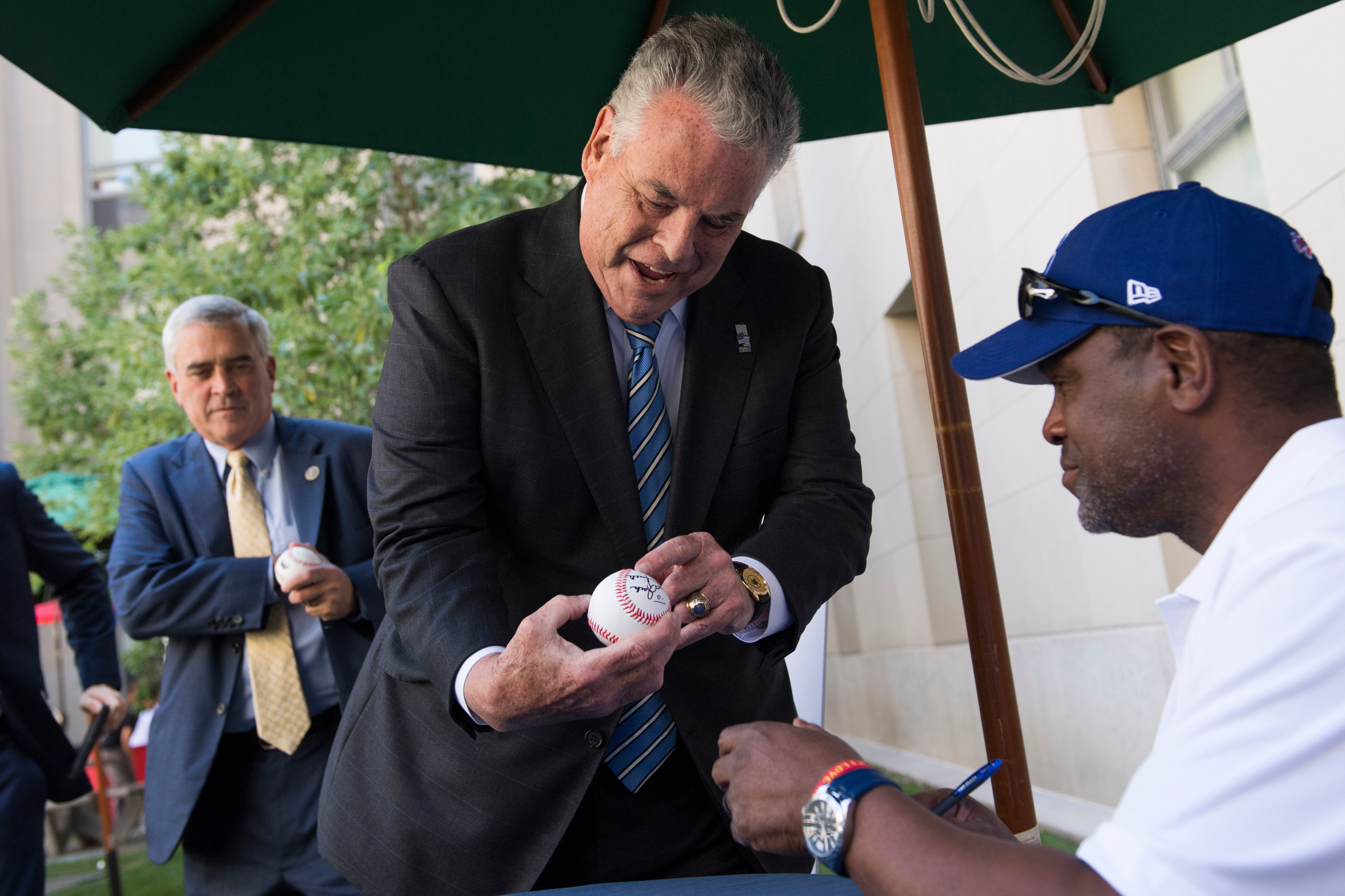 UNITED STATES - JULY 18: Rep. Peter King, R-N.Y., gets his baseball signed by Hall of Fame member Tim Raines, during the American Meat Institute's annual Hot Dog Lunch in the Rayburn courtyard on July 18, 2018. Rep. Brad Wenstrup, R-Ohio, also appears. (Photo By Tom Williams/CQ Roll Call)