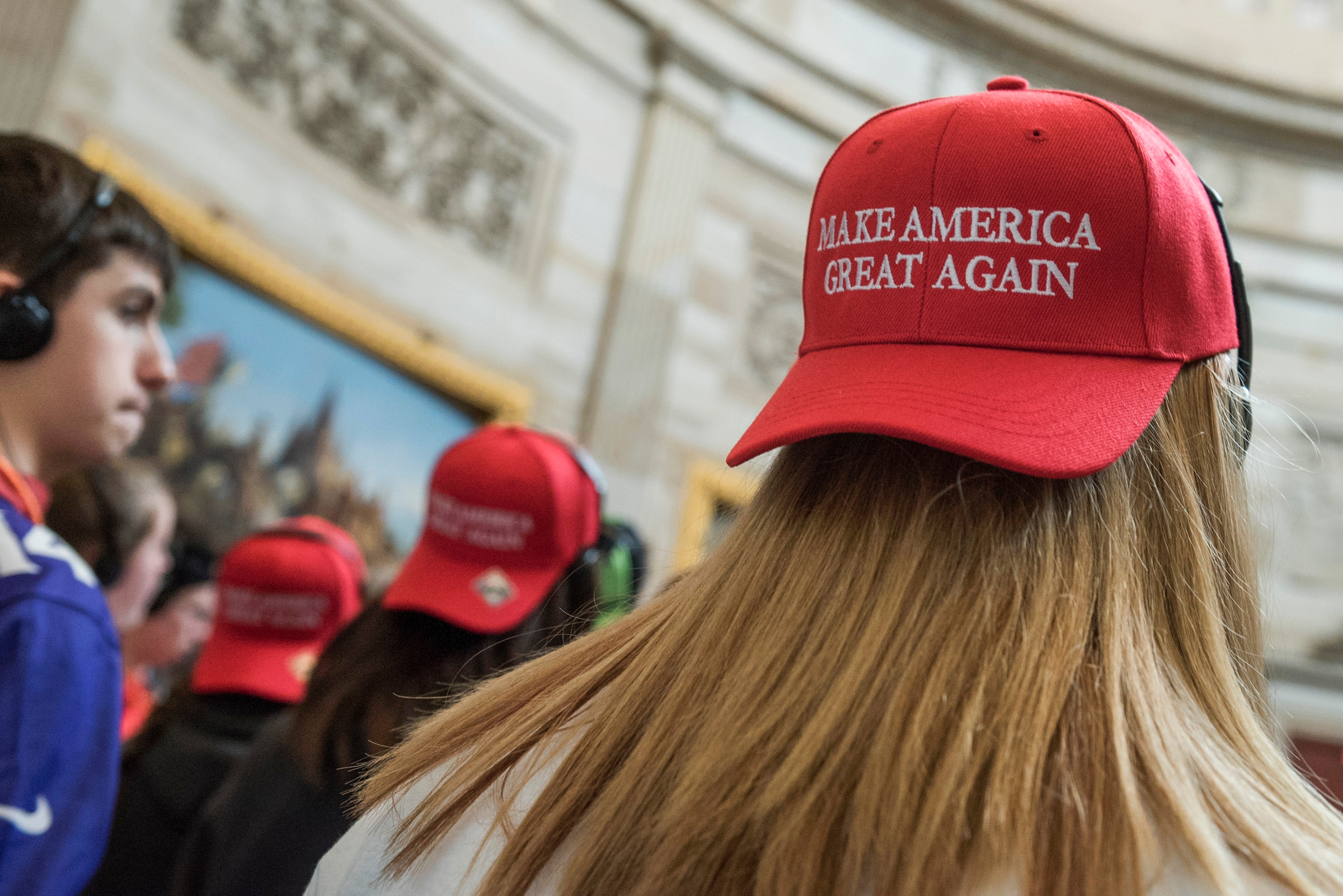 Tourists from North Carolina don “Make America Great Again” hats in the Capitol Rotunda in March 2017. (Tom Williams/CQ Roll Call file photo)