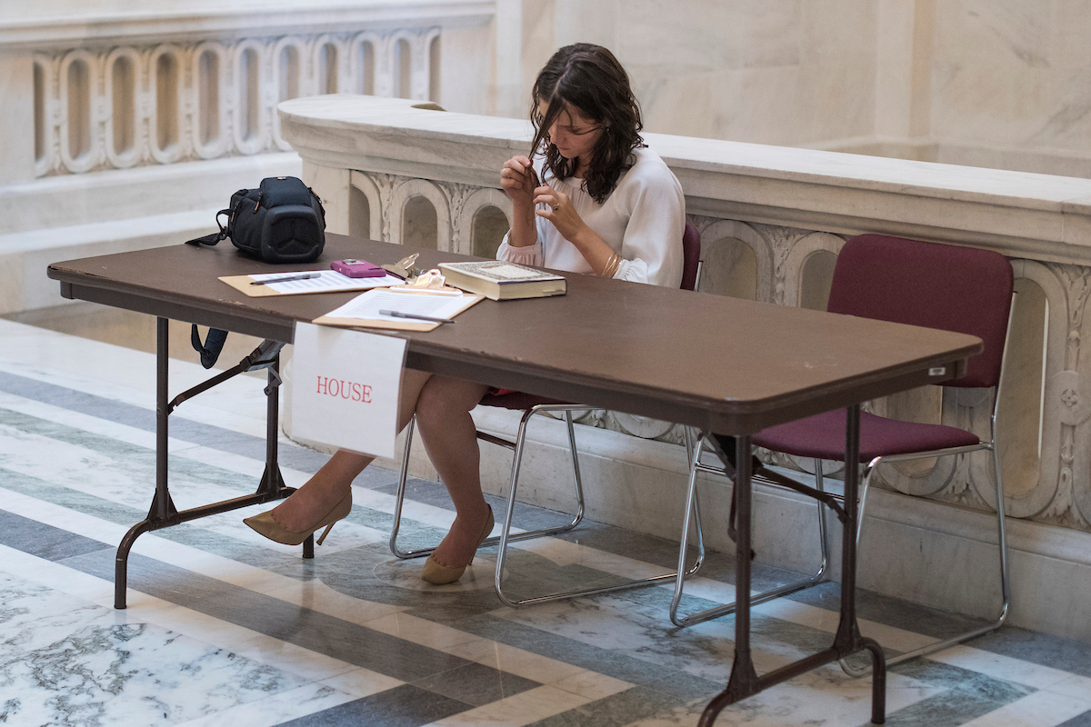 An intern for House Administration Committee chairman Rep. Gregg Harper, R-Miss., works a sign-in table outside of an Intern Lecture Series event in Russell Building on July 20, 2018. (Tom Williams/CQ Roll Call file photo)