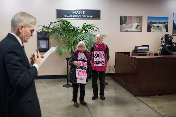 UNITED STATES - NOVEMBER 28: Demonstrators from Code Pink protest Saudi Arabia's war in Yemen as Sen. Bill Cassidy, R-La., walks by in the basement of Hart Building on November 28, 2018. (Photo By Tom Williams/CQ Roll Call)