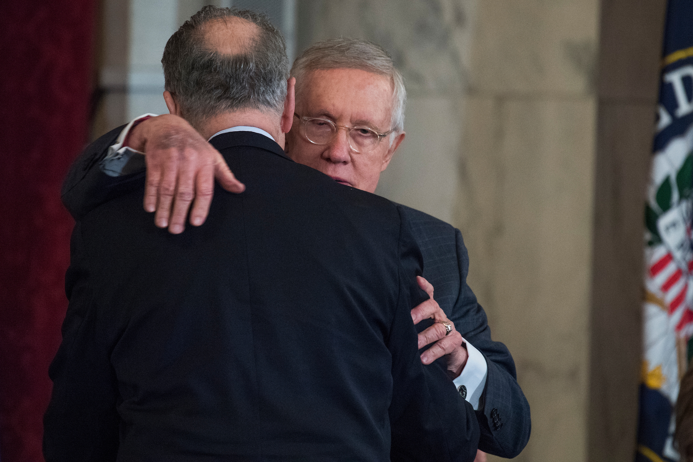 Former Senate Minority Leader Harry Reid, D-Nev., right, hugs his successor, Senate Minority Leader Charles E. Schumer, D-N.Y., during Reid’s portrait unveiling ceremony in December 2016. (Tom Williams/CQ Roll Call file photo)