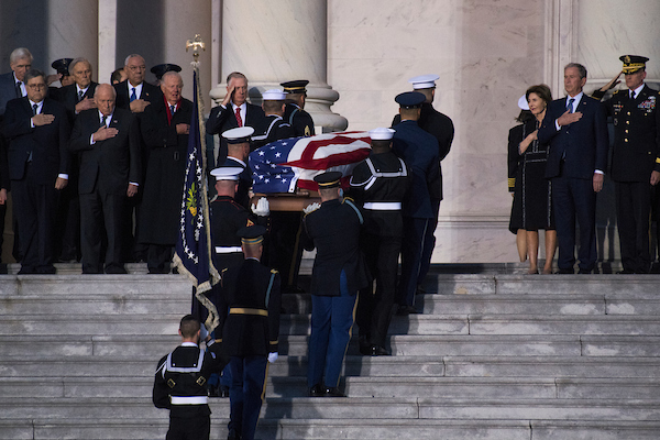UNITED STATES - DECEMBER 3: The casket of the late George H.W. Bush arrives on the East Front of the Capitol to lie in state in the Rotunda on December 3, 2018. Seen at right is his son, former President George W. Bush, and former First Lady Laura Bush. Also pictured to the left of the casket, from right, are Dan Quayle, James Baker, Colin Powell, and Dick Cheney. He passed away Friday at age 94. (Photo By Tom Williams/CQ Roll Call)