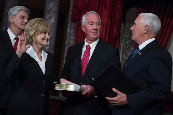 Sen. Cindy Hyde-Smith, R-Miss., participates in her swearing-in ceremony in the Capitol's Old Senate Chamber with Vice President Mike Pence, right, and her husband Michael, after being sworn in on the Senate floor on April 9, 2018. Mississippi Gov. Phil Bryant appears at left. (Tom Williams/CQ Roll Call)