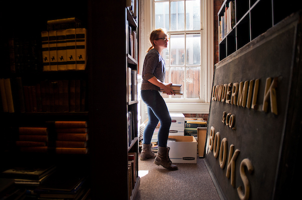 Lori Grisham, manager of Riverby Books on East Capitol St., SE, stacks books while setting up the store for it's reopening this month, October 15, 2015. (Tom Williams/CQ Roll Call)