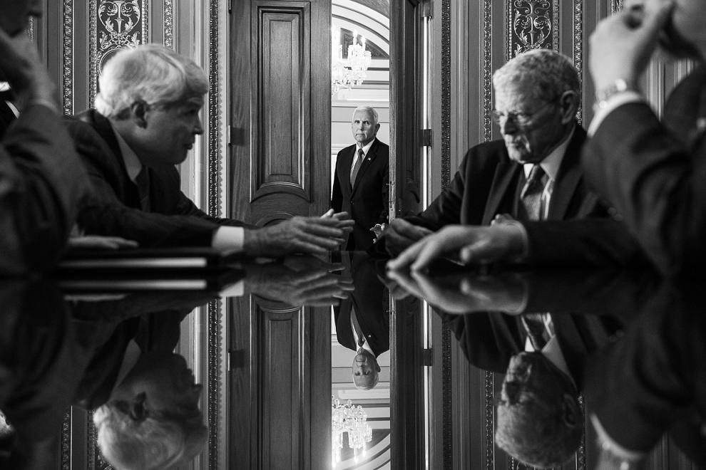 The above photo, by Roll Call staff photographer Tom Williams, has won WHNPA’s political photo of the year. In the image, Vice President Mike Pence is seen in the Senate Reception Room as Sen. James Inhofe, R-Okla., right, conducts a meeting on July 10, 2018. (Tom Williams/CQ Roll Call)