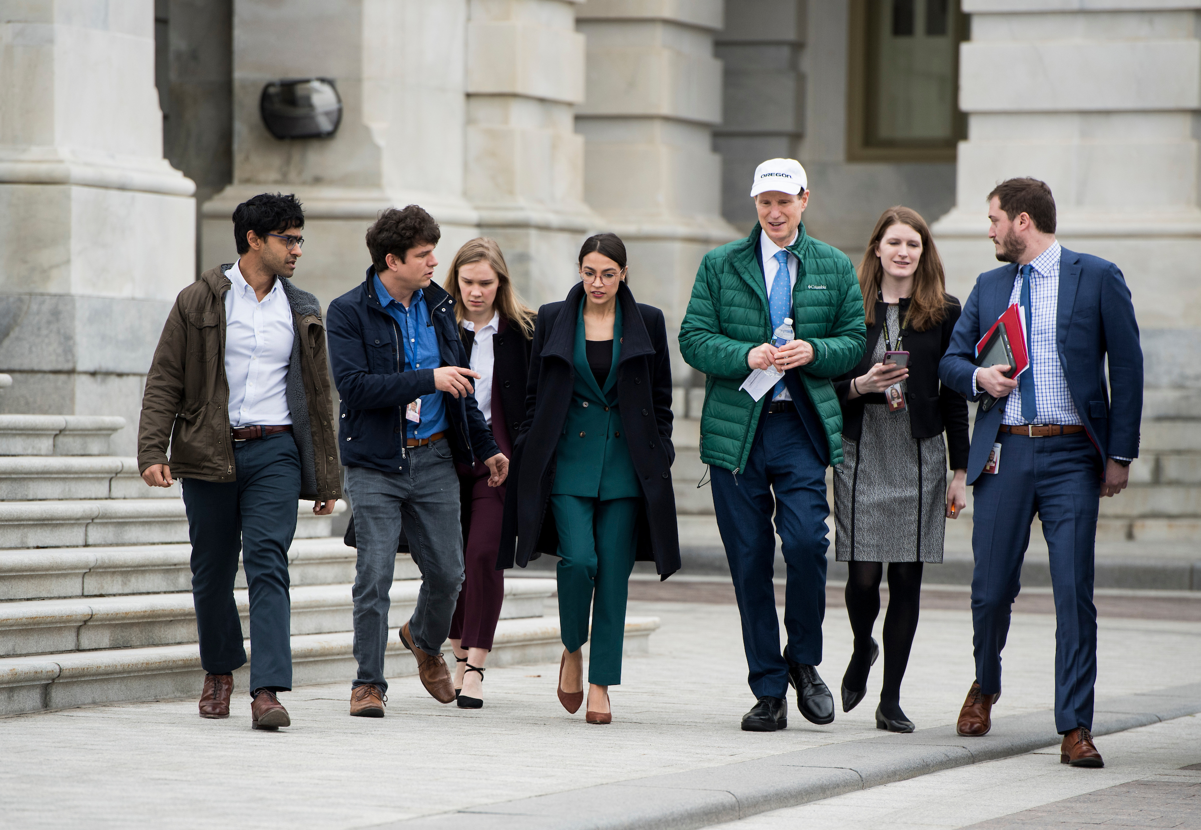 New York Rep. Alexandria Ocasio-Cortez, center, and Oregon Sen. Ron Wyden, third from right, arrive with staff members for a press conference on the Green New Deal outside the Capitol on Feb. 7. (Bill Clark/CQ Roll Call file photo)