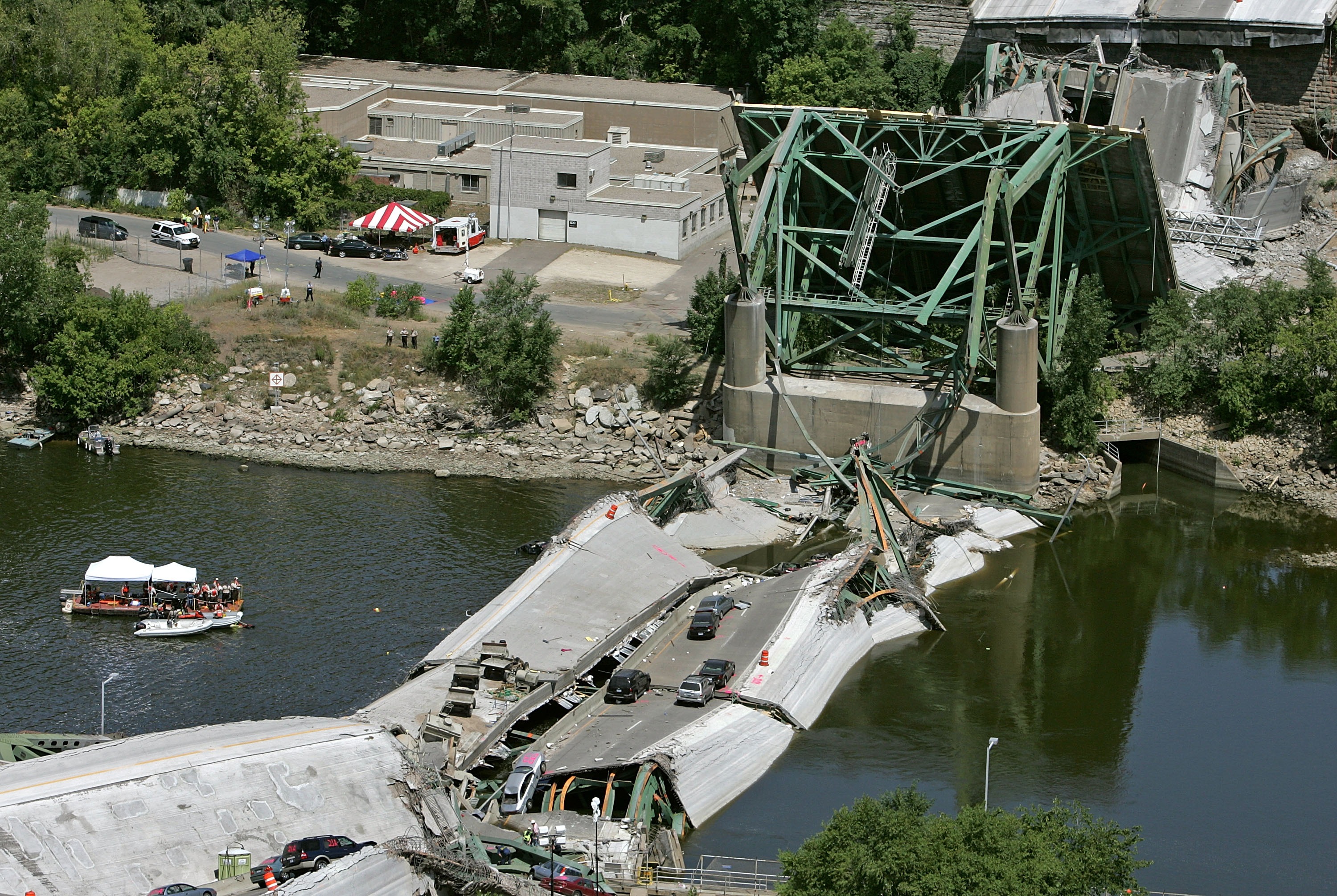 Rescue workers and a dive team work off a barge after a section of the I-35W bridge collapsed in August 2007 in Minneapolis. The eight lane steel and concrete bridge spanning the Mississippi River near the city's downtown was undergoing repair work, when it collapsed during the evening rush hour. (Mark Wilson/Getty Images file photo)