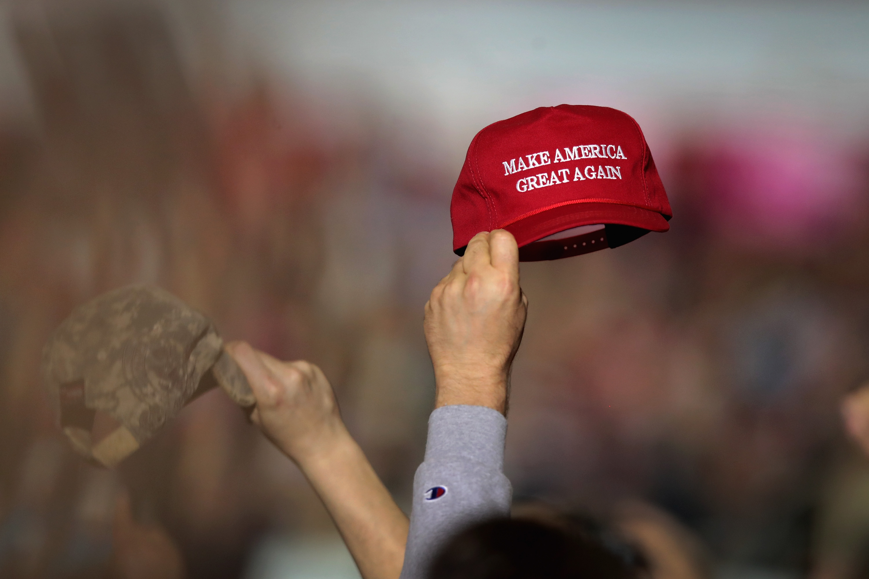 Supporters wave caps as they listen as President Donald Trump speaks at a campaign rally on April 28, 2018 in Michigan. He was back in the state for another rally on Thursday night. (Photo by Scott Olson/Getty Images)