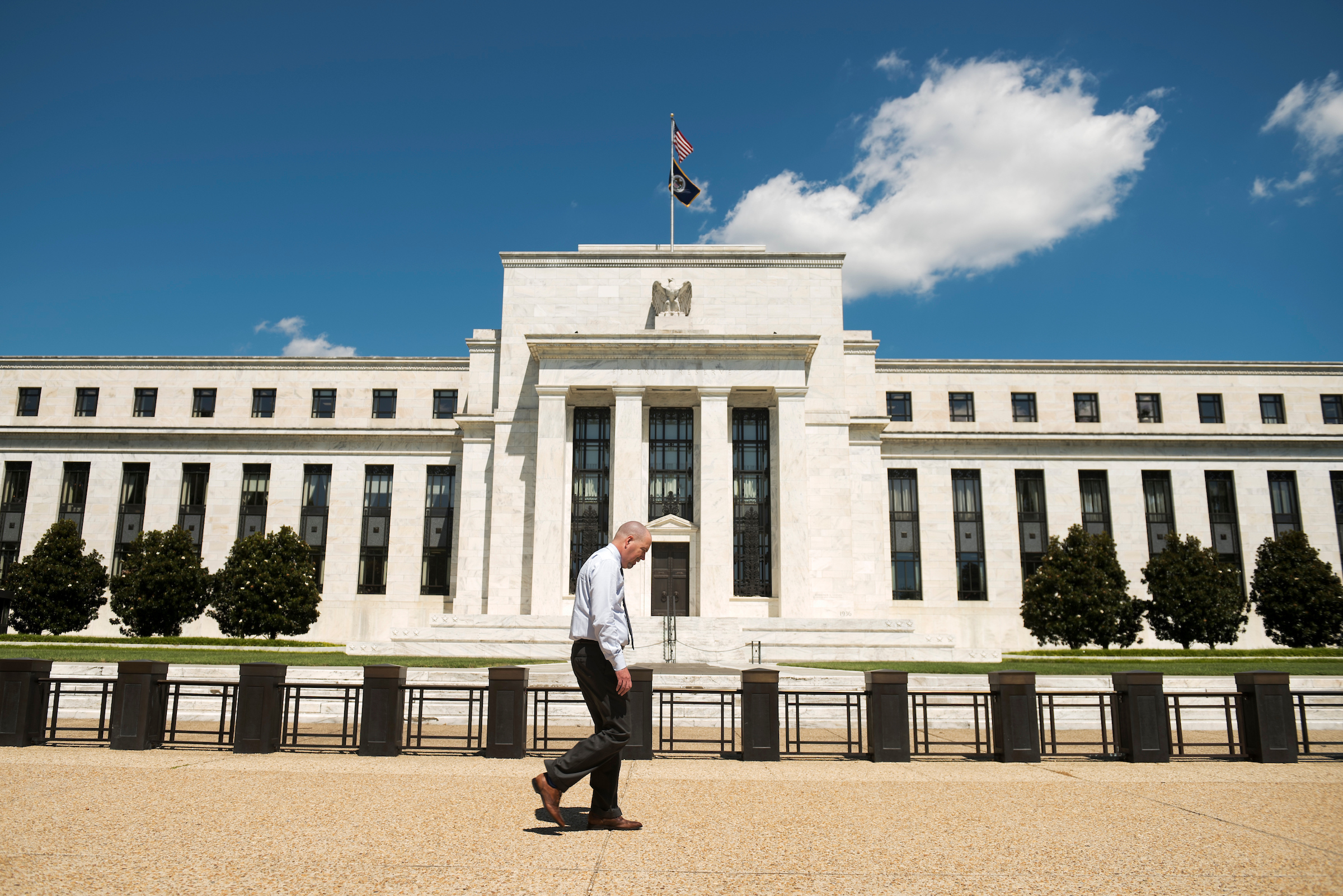 A man walks by the Marriner S. Eccles Federal Reserve Board Building in Washington, D.C.. Herman Cain will not get a Fed seat after all, President Trump announced Monday. (Photo By Tom Williams/CQ Roll Call)