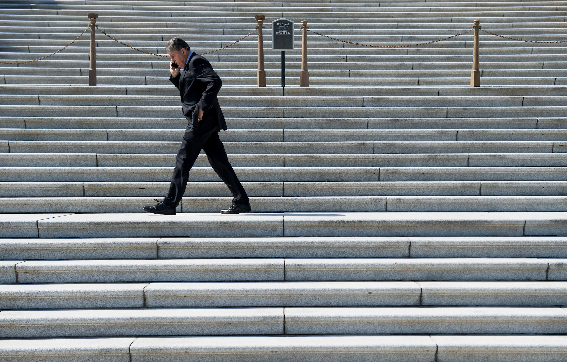 UNITED STATES - MARCH 14: Sen. Joe Manchin, D-W. Va., talks on his phone as he walks along the Senate steps before the vote on legislation to reverse President Trump's national emergency declaration concerning the U.S.-Mexico border on Thursday, March 14, 2019. (Photo By Bill Clark/CQ Roll Call)