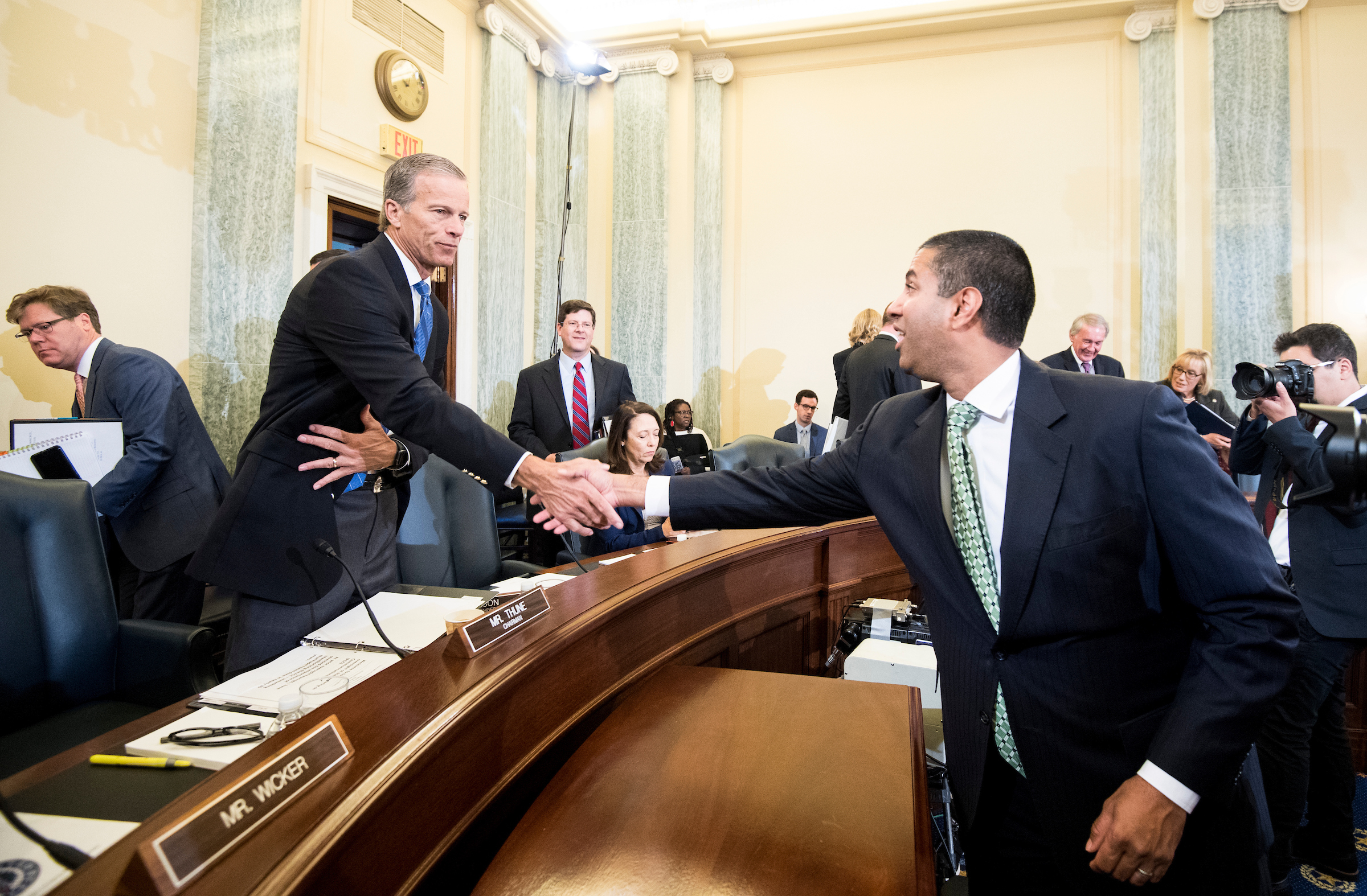 From left, chairman Sen. John Thune, R-S.D., shakes hands with Ajit Pai, chairman of the Federal Communications Commission, before the start of the Senate Committee on Commerce, Science, and Transportation hearing on Aug. 16, 2018. (Bill Clark/CQ Roll Call file photo)