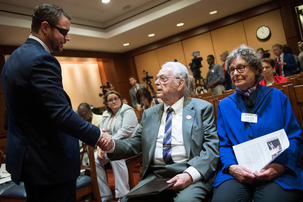 UNITED STATES - JUNE 4: Rep. Dan Crenshaw, R-Texas, greets Holocaust survivor Steven Joseph Fenves of Rockville, Md., and his wife Norma, during an event with the U.S. Holocaust Memorial Museum to honor the 75th anniversary of D-Day in the Capitol Visitor Center on Tuesday, June 4, 2019. Fenves was born in Yugoslavia on June 6, 1931. (Photo By Tom Williams/CQ Roll Call)