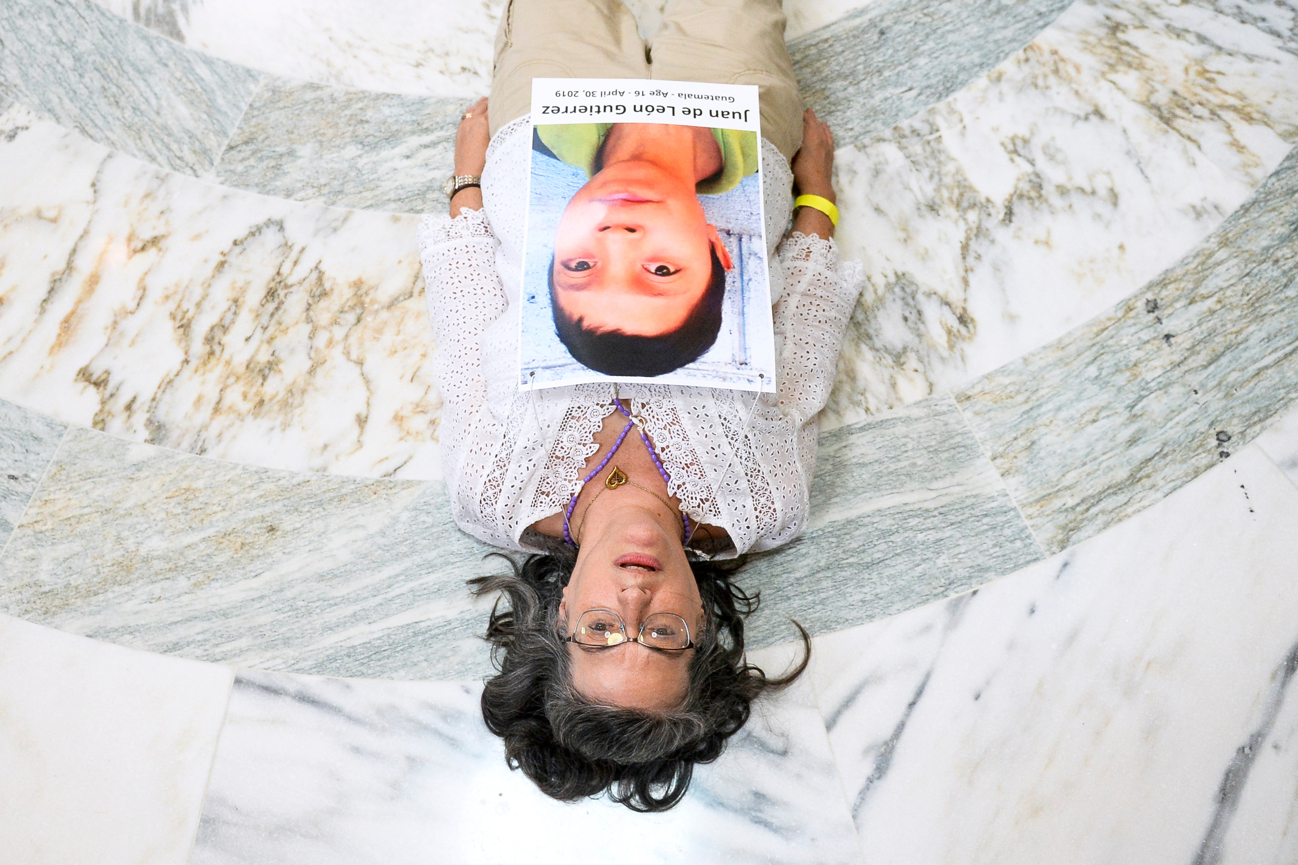 UNITED STATES - JULY 18: A woman a part of a coalition of Catholic activists lays on the ground as she protests to pressure the Trump administration and Congress to end the practice of detaining immigrant children in the Russell Rotunda at the Capitol on Thursday July 18, 2019. (Photo by Caroline Brehman/CQ Roll Call)