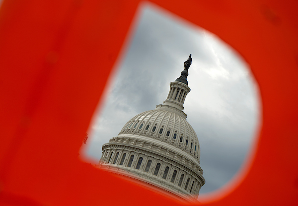 The Capitol dome is frame by a protest sign as a coalition of progressive activist groups rallies at the Capitol for Congress to impeach President Trump. (Caroline Brehman/CQ Roll Call file photo)