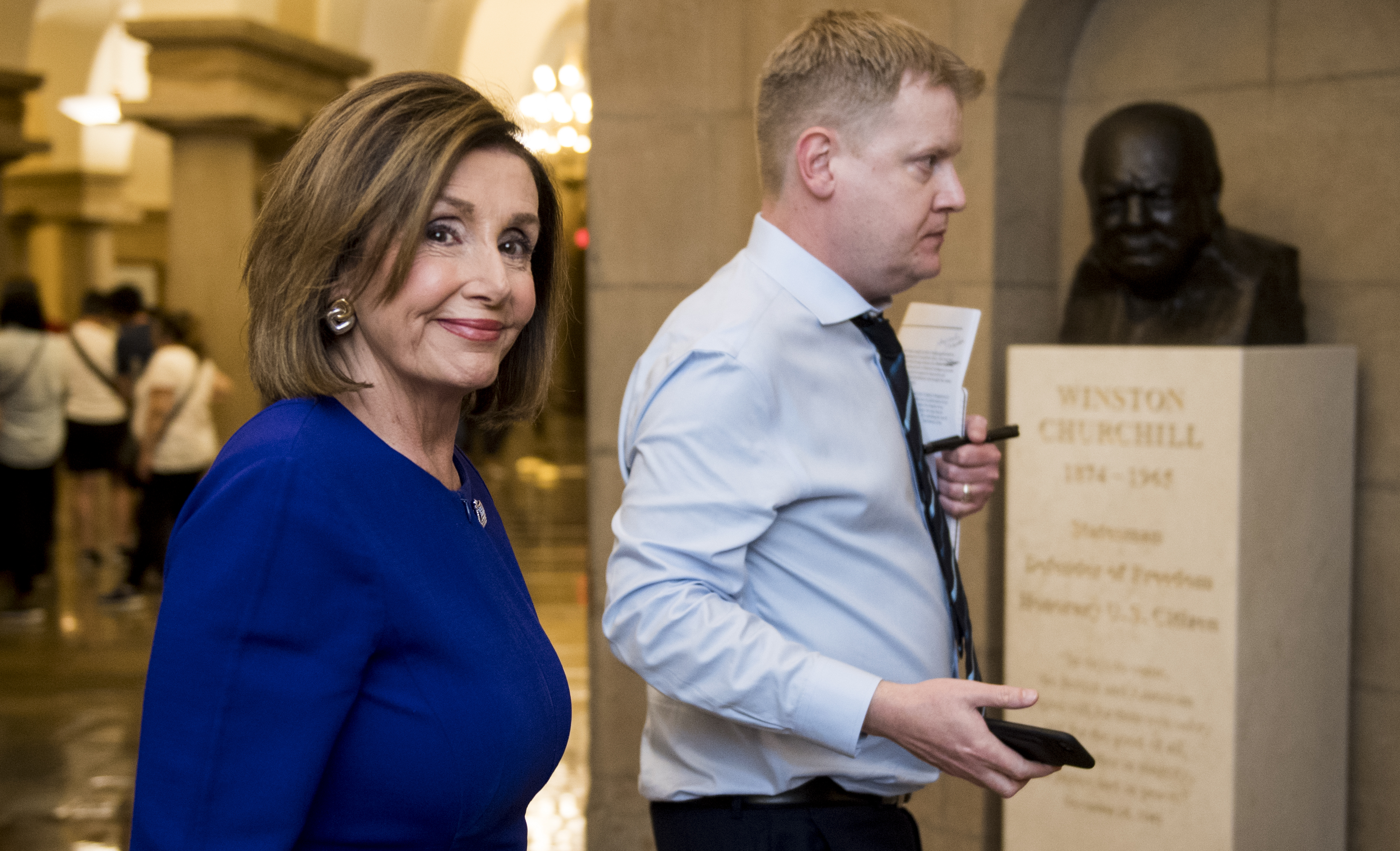 UNITED STATES - SEPTEMBER 24: Speaker of the House Nancy Pelosi, D-Calif., walks with her Deputy Chief of Staff Drew Hamill past the Sir Winston Churchill bust as she exits the Capitol on Tuesday, Sept. 24, 2019. (Photo By Bill Clark/CQ Roll Call)