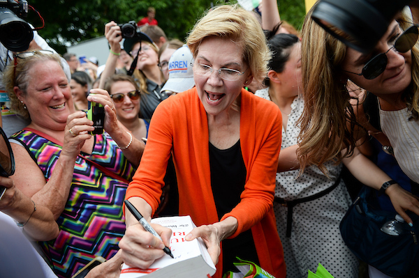 UNITED STATES - AUGUST 10: Democratic presidential candidate Sen. Elizabeth Warren, D-Mass., signs a copy of the Mueller Report for a fairgoer at the Iowa State Fair on Saturday August 10, 2019. (Photo by Caroline Brehman/CQ Roll Call)