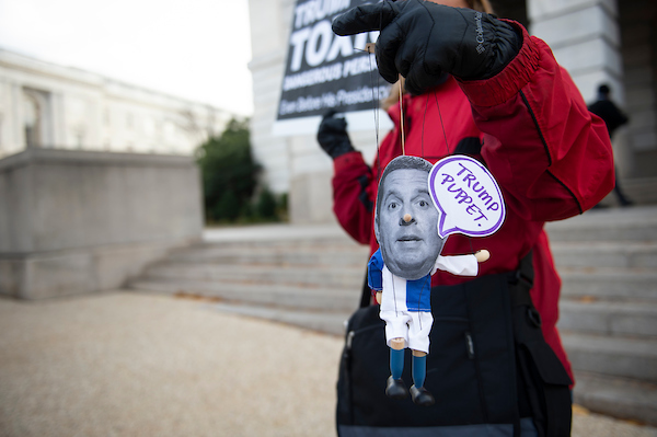 A protester holds up a puppet of California Rep. Devin Nunes on Nov. 20 as Gordon Sondland, the U.S. ambassador to the European Union, testifies before the House Intelligence Committee in the impeachment inquiry into President Donald Trump. Nunes has threatened to sue media outlets that reported he met with Ukrainian officials to get help compiling a committee report when he was chairman of the Intelligence panel. (Caroline Brehman/CQ Roll Call)