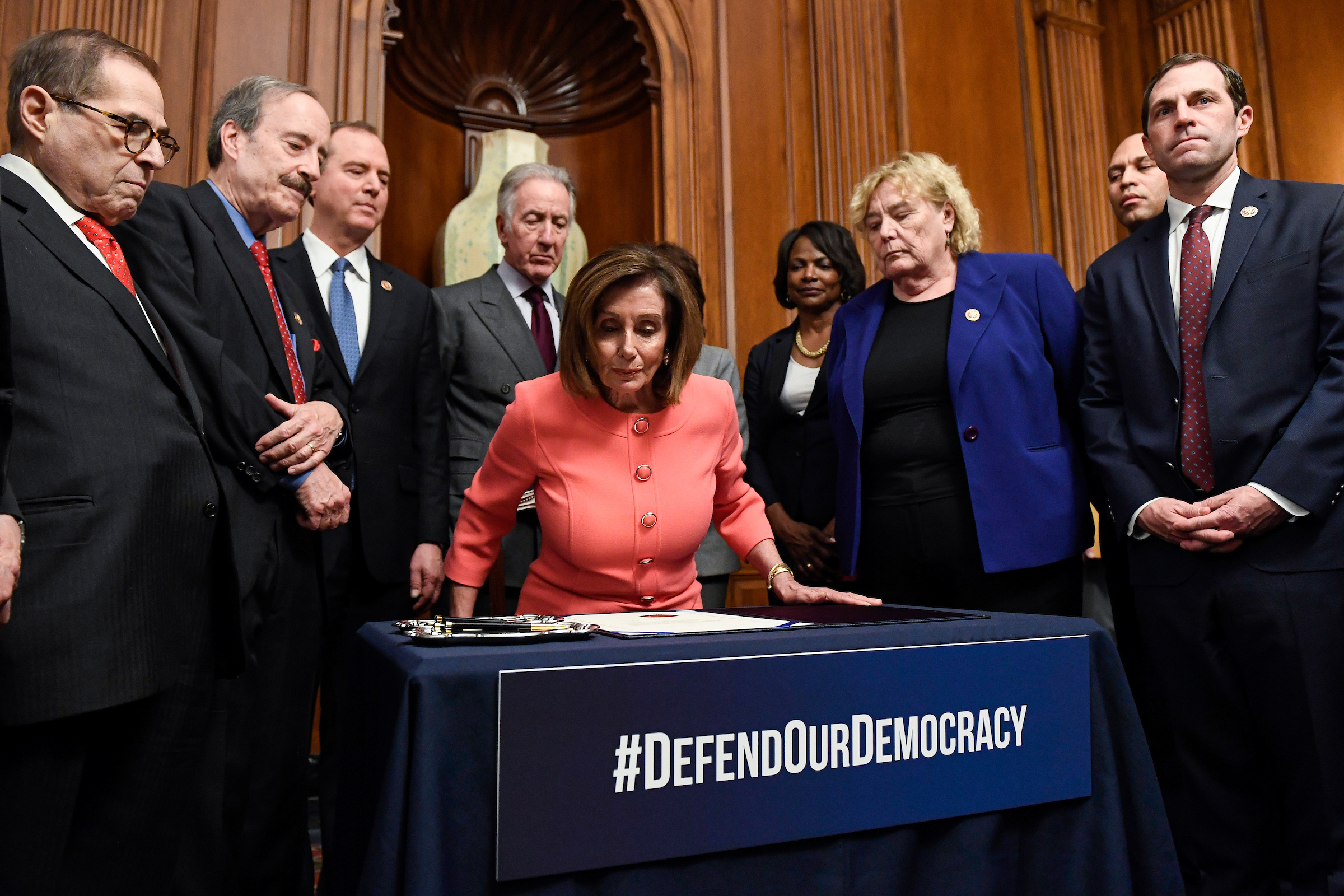 Speaker Nancy Pelosi gets up after signing the articles of impeachment during an engrossment ceremony Wednesday. (Caroline Brehman/CQ Roll Call)