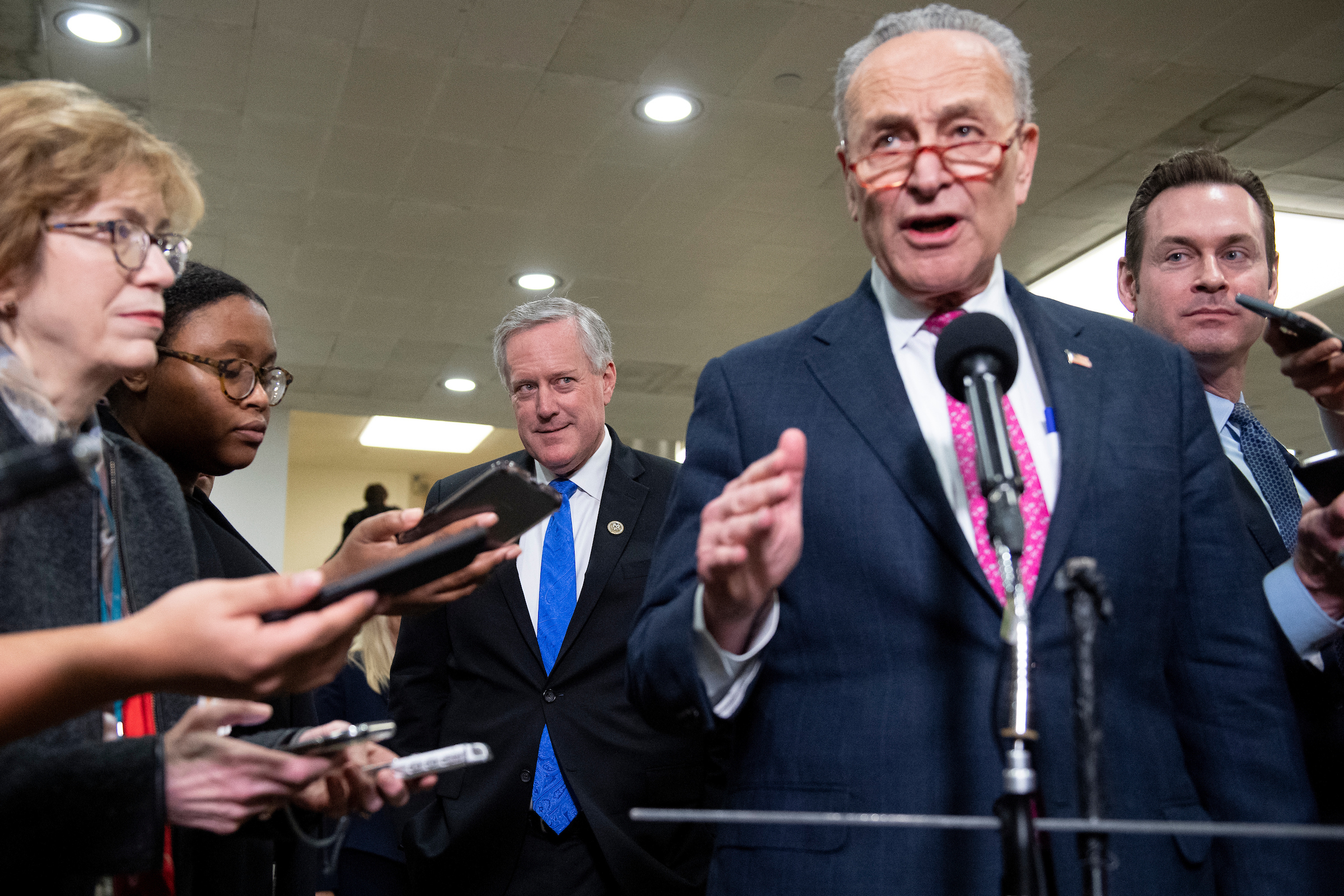 Republican Rep. Mark Meadows watches Senate Minority Leader Charles E. Schumer talk to reporters in the Senate subway during a break in President Donald Trump’s impeachment trial. (Caroline Brehman/CQ Roll Call)