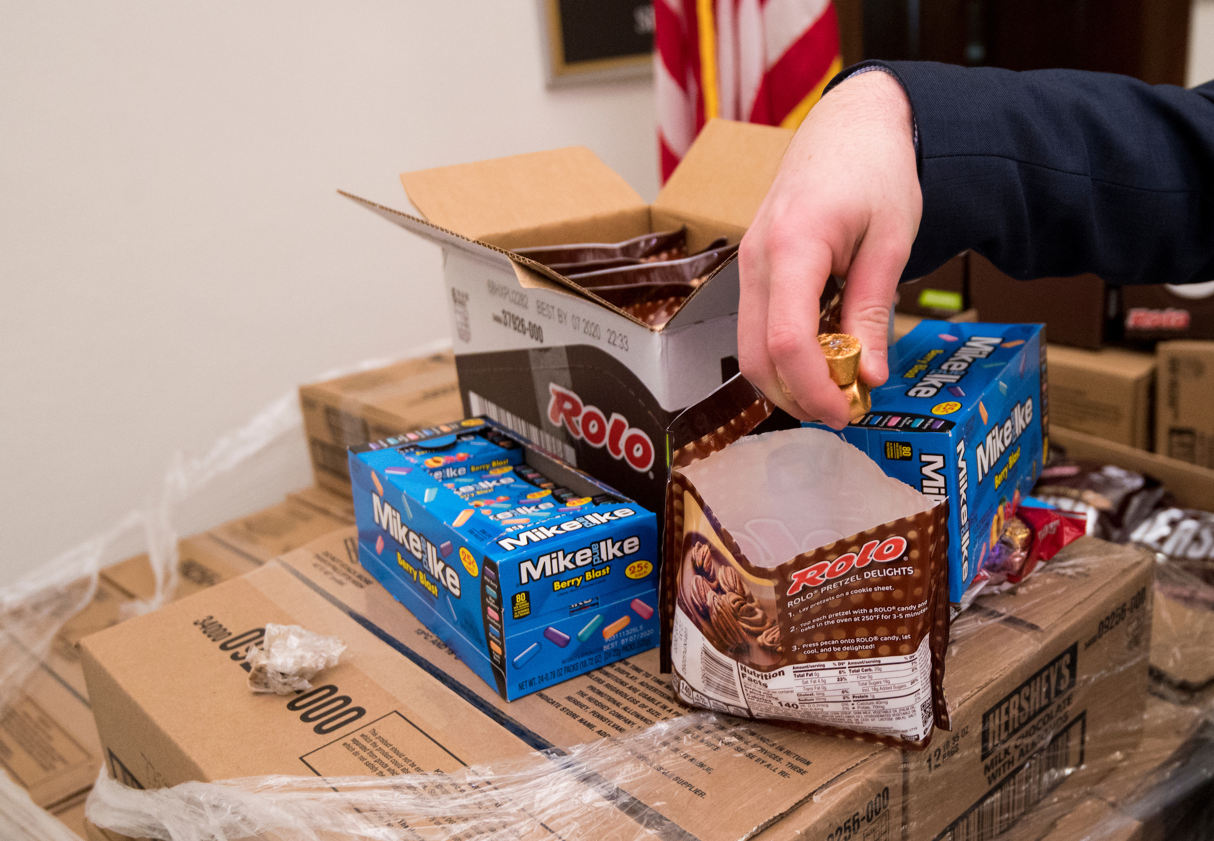 UNITED STATES - JANUARY 24: A reporter grabs a handful of Rolos from a pallet of Hersheys candy outside of office of Sen. Pat Toomey, R-Pa., on Friday, Jan. 24, 2020. The candy was sent by Hersheys to resupply Sen. Toomey’s desk on the Senate floor, known as the candy desk, for the impeachment trial. (Photo By Bill Clark/CQ Roll Call)